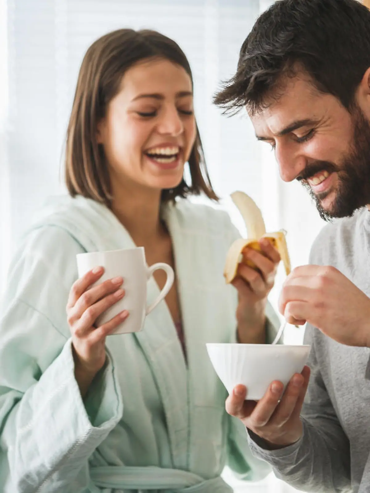 Young man and his wife are having fruit and cereals for breakfast.