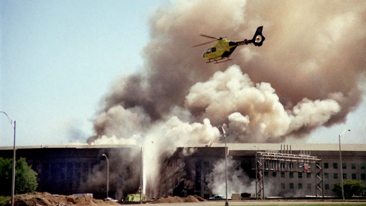 ARCHIV - 11.09.2001, USA, Washington: Ein Hubschrauber fliegt über das Pentagon, während Rauchschwaden über dem Gebäude aufsteigen, nachdem ein entführtes Flugzeug in die Westseite des Gebäudes gestürzt war. (zu dpa «20 Jahre 9/11: Terroranschläge in den USA») Foto: Heesoon Yim/AP/dpa +++ dpa-Bildfunk +++