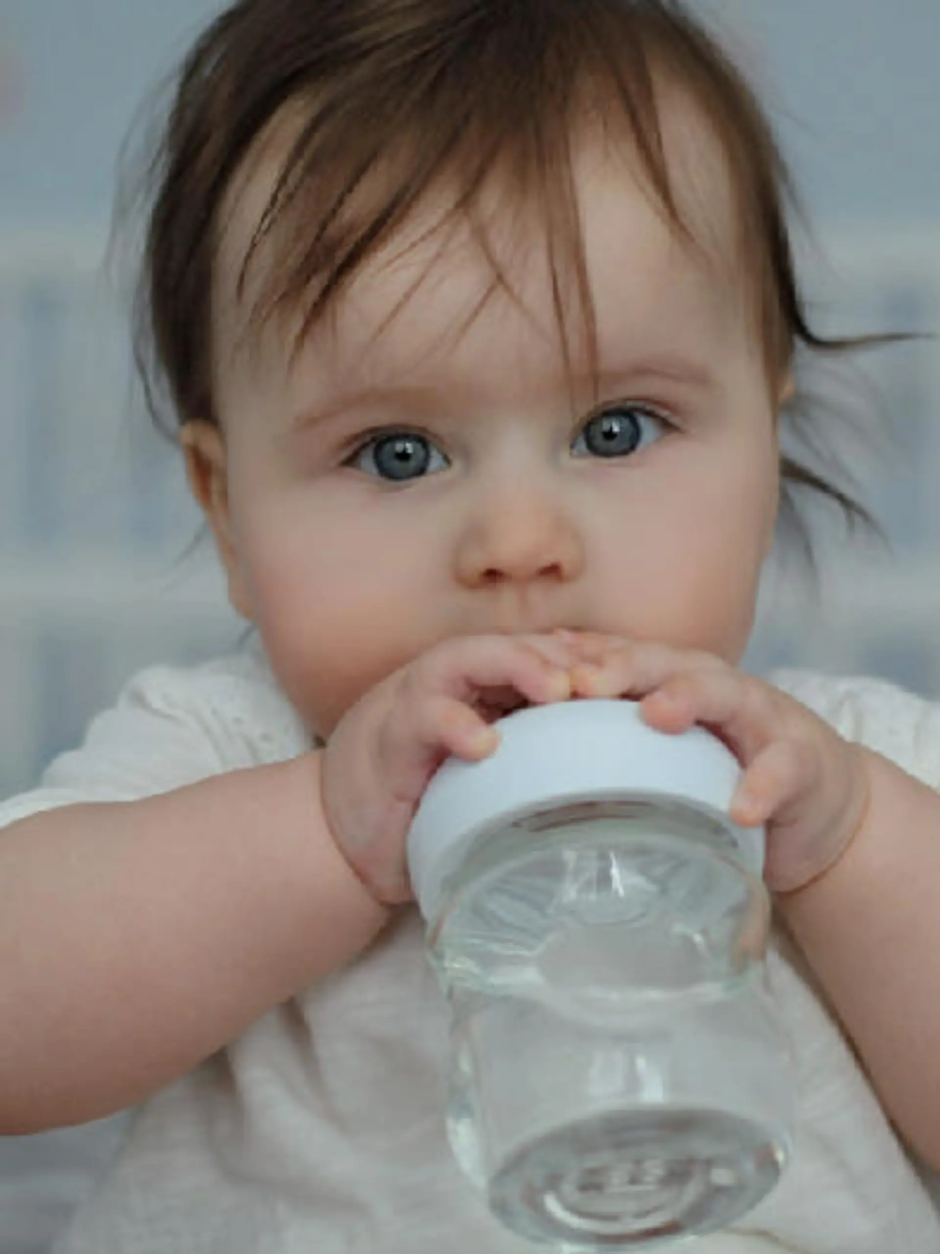 Baby nuckelt an Fläschen mit Wasser
