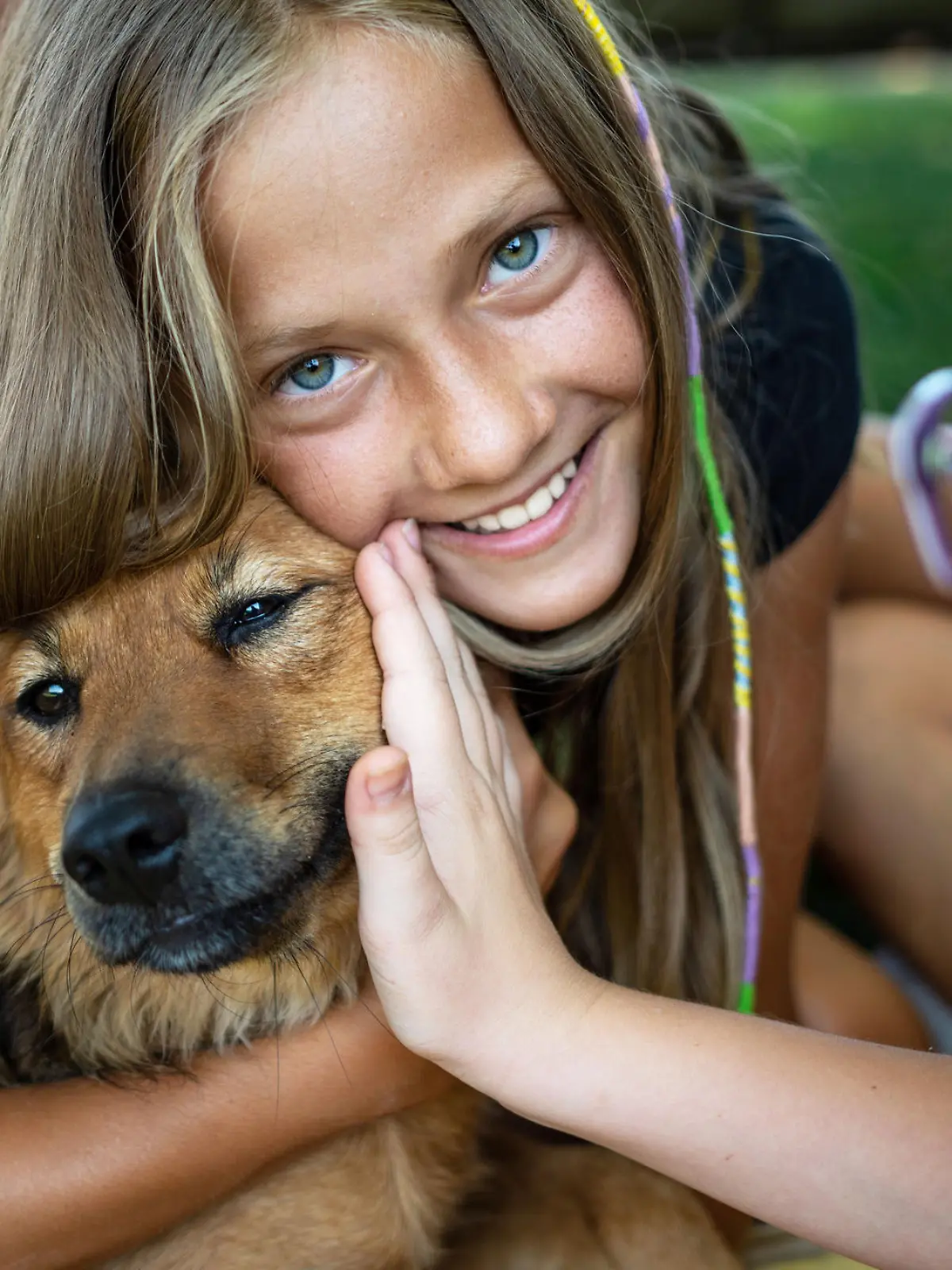 Twin sister teenage girl playing with dog in backyard