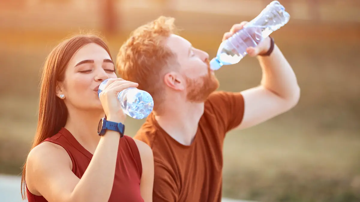 Modern couple making pause in an urban park during jogging / exercise.