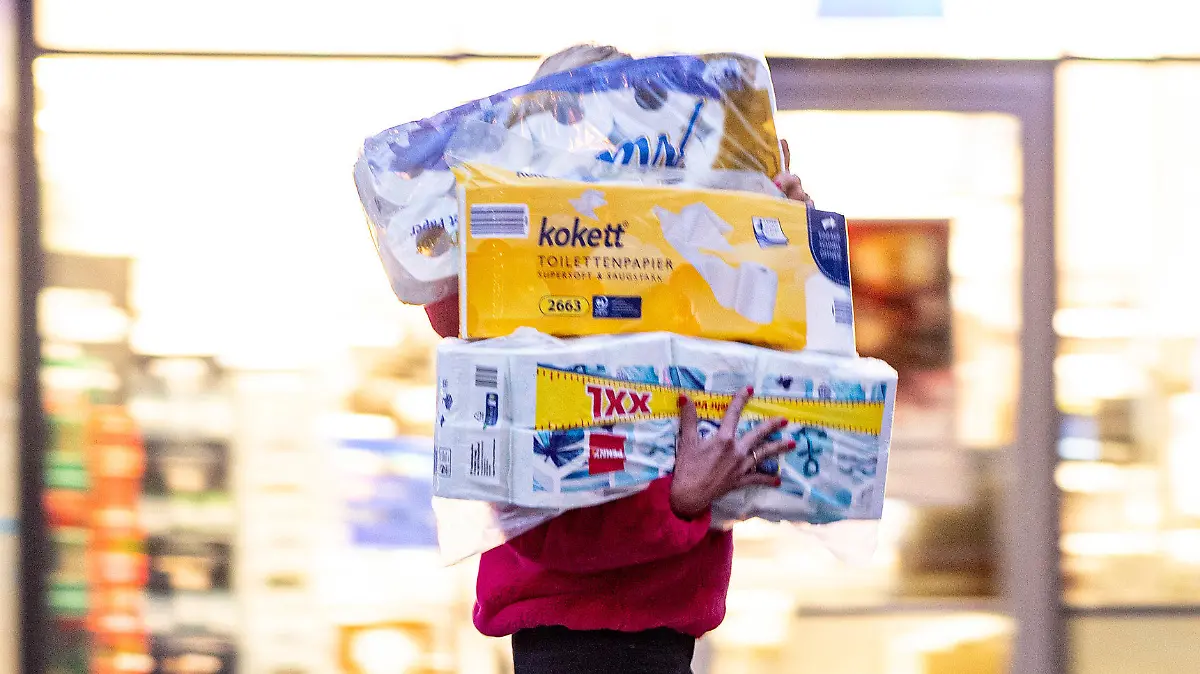 05.11.2020, Hamburg: Ein Frau läuft mit dem Arm voller Klopapierrollen aus einem Drogeriemarkt heraus. Gähnend leere Regale, wo sonst das Toilettenpapier thronte, waren im März dieses Jahres keine Seltenheit in deutschen Supermärkten. Weil viele der strengeren Corona-Regeln ein Comeback feiern, werden mancherorts die weißen Rollen wieder rar. Foto: Axel Heimken/dpa +++ dpa-Bildfunk +++