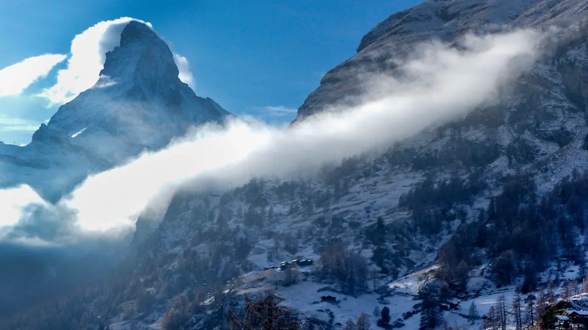 02.12.2020, Schweiz, Zermatt: Eine Frau fotografiert das Matterhorn (l). Die Schweiz verschärft angesichts der weiterhin bedrohlichen Corona-Situation ihre Maßnahmen. Im Prinzip wolle die Schweiz die Skigebiete für den Inlandstourismus offen halten, für die EU-Mitgliedsstaaten Österreich, Frankreich, Deutschland und Italien gelten Beschränkungen. Foto: Jamey Keaten/AP/dpa +++ dpa-Bildfunk +++