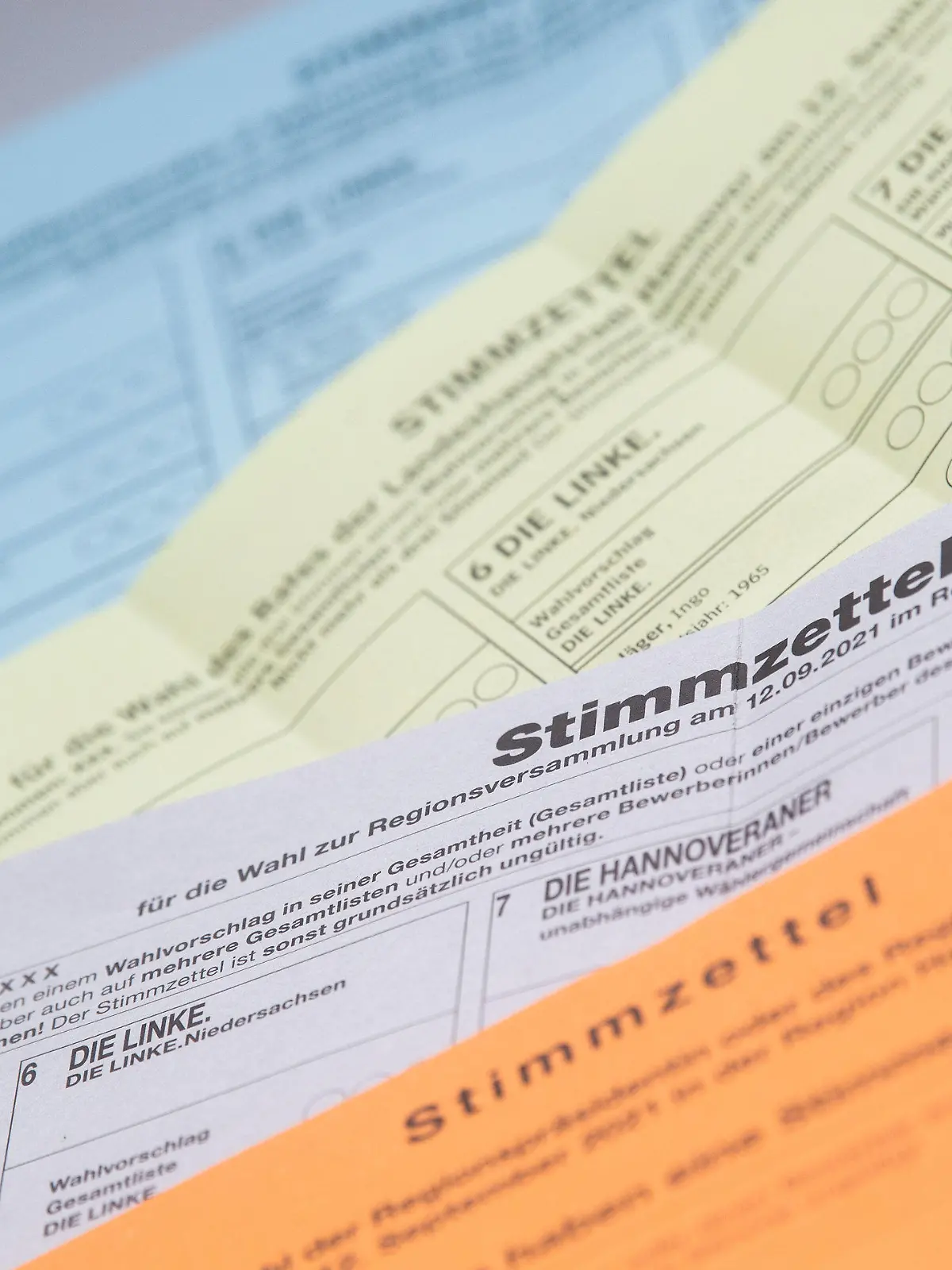SYMBOLBILD - 18.08.2021, Niedersachsen, Hannover: Muster von Stimmzettel für die Kommunalwahlen 2021 in Niedersachsen - hier die Wahlen zum Stadtbezirksrat, Stadtrat, Regionsversammlung und Regionspräsident/-in - liegen auf einem Tisch. Immer mehr Wählerinnen und Wähler in Niedersachsen geben ihre Stimme per Brief ab. Für die Kommunalwahl am 12. September sind in manchen Städten bis Ende August schon mehr Briefwahlanträge eingegangen als zur vorherigen Wahl im Jahr 2016 insgesamt. (zu dpa «Interesse an Briefwahl in Niedersachsen hoch») Foto: Julian Stratenschulte/dpa +++ dpa-Bildfunk +++
