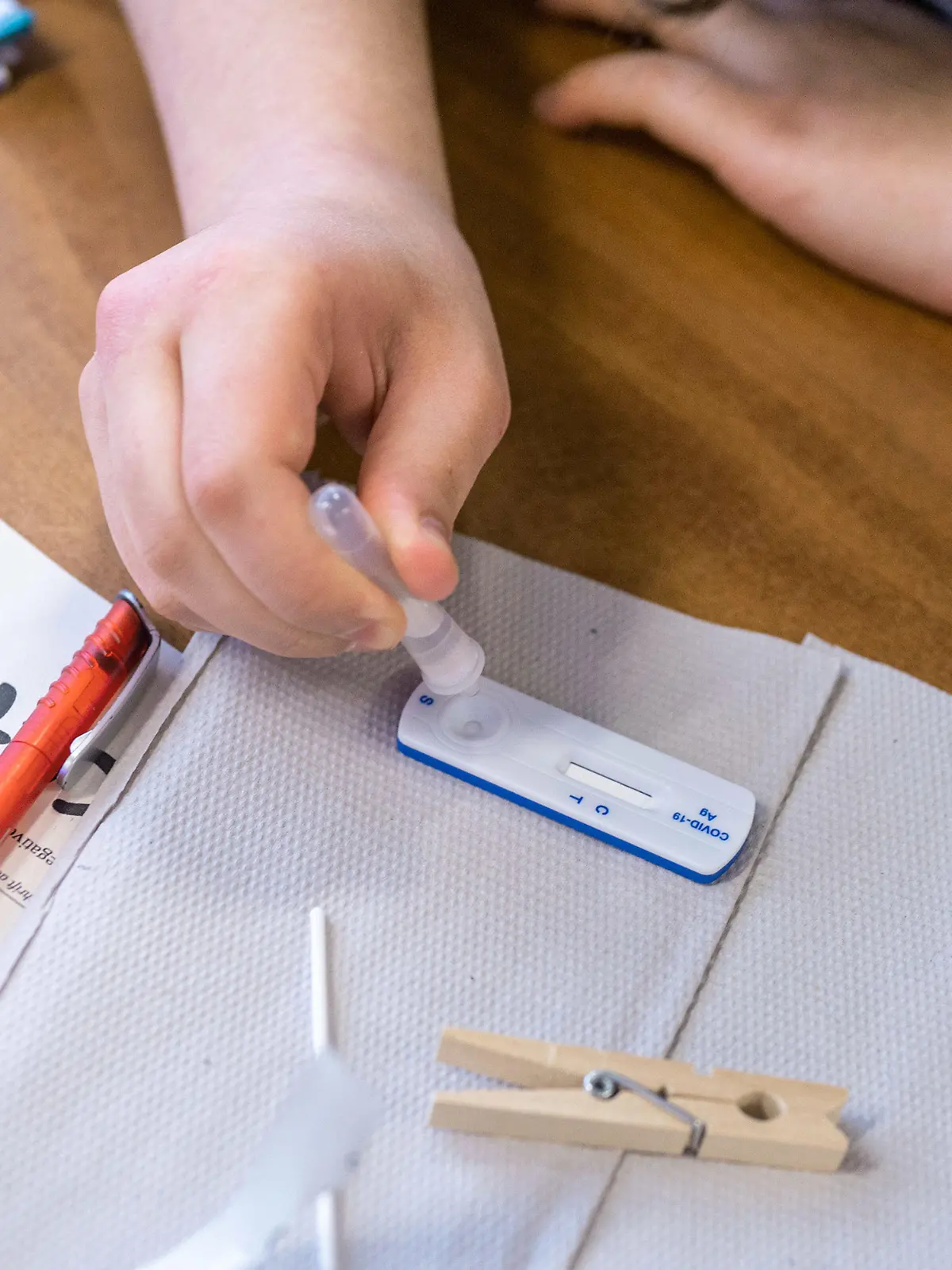 ARCHIV - 19.04.2021, Nordrhein-Westfalen, Köln: Eine Schülerin macht vor Unterrichtsbeginn in der Katharina Henoth-Gesamtschule einen Corona-Antigen-Schnelltest. Köln plant einen Modellversuch, bei dem nur noch positiv getestete Schüler in Quarantäne sollen.          (zu dpa «Modellversuch in Köln geplant: Quarantäne nur für infizierte Schüler») Foto: Marius Becker/dpa - ACHTUNG: Name auf Formular gepixelt +++ dpa-Bildfunk +++
