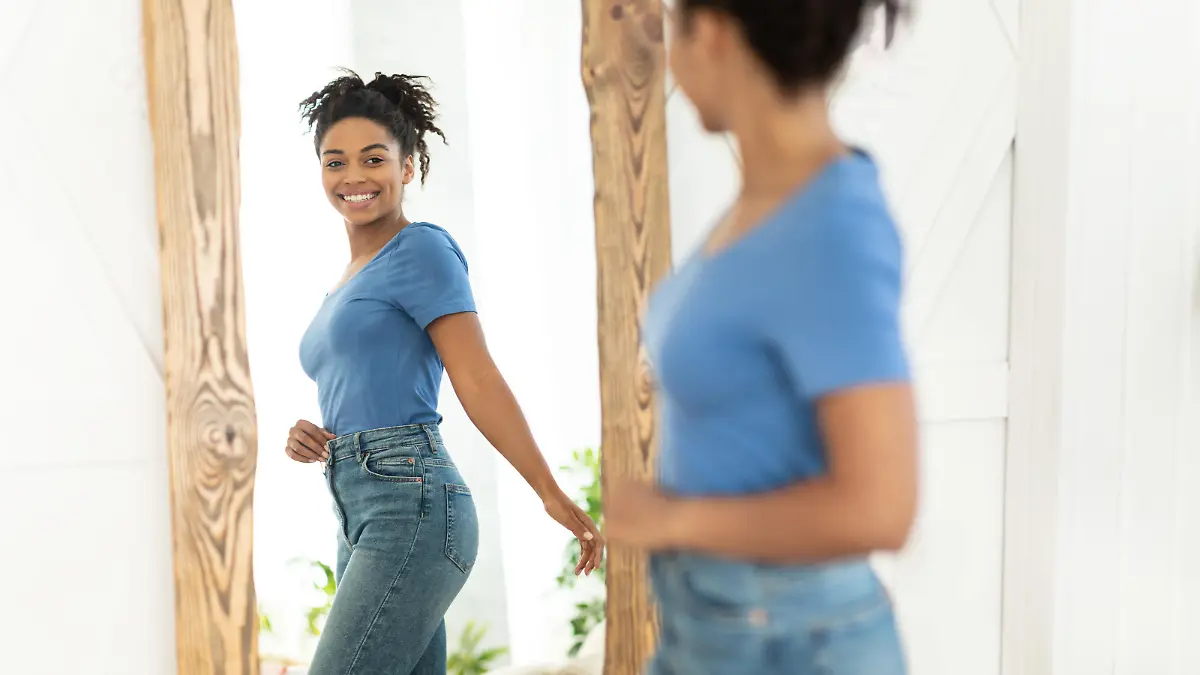 Successful Weight Loss. Joyful African American Girl After Slimming Smiling To Her Reflection In Mirror Standing At Home. Staying Fit, Dieting And Weight-Loss Concept. Selective Focus