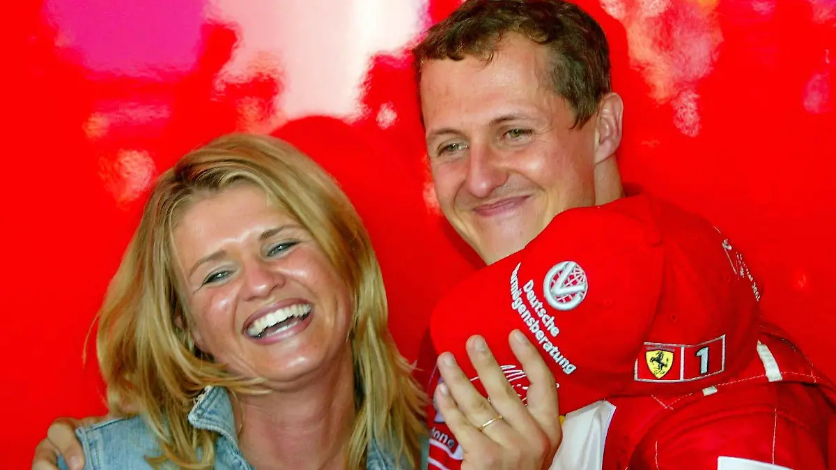 ARCHIV - Michael Schumacher hält seine lachende Ehefrau Corinna im Arm im französischen Magny Cours (Archivfoto vom 21.07.2002). Am kommenden Sonntag (22.10.2006) beim Grand Prix im brasilianischen Sao Paulo, dem Saisonfinale, fährt Michael Schumacher sein letztes Formel-1-Rennen und beendet danach seine Karriere als Formel-1-Fahrer. Foto: Oliver Multhaup  +++(c) dpa - Bildfunk+++