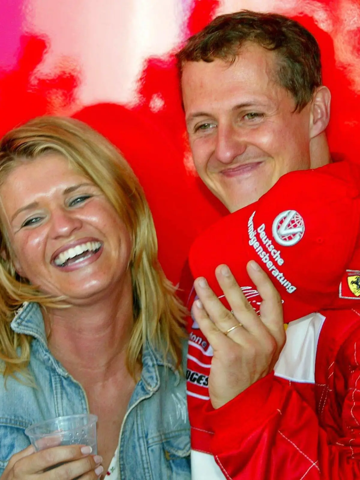 ARCHIV - Michael Schumacher hält seine lachende Ehefrau Corinna im Arm im französischen Magny Cours (Archivfoto vom 21.07.2002). Am kommenden Sonntag (22.10.2006) beim Grand Prix im brasilianischen Sao Paulo, dem Saisonfinale, fährt Michael Schumacher sein letztes Formel-1-Rennen und beendet danach seine Karriere als Formel-1-Fahrer. Foto: Oliver Multhaup  +++(c) dpa - Bildfunk+++