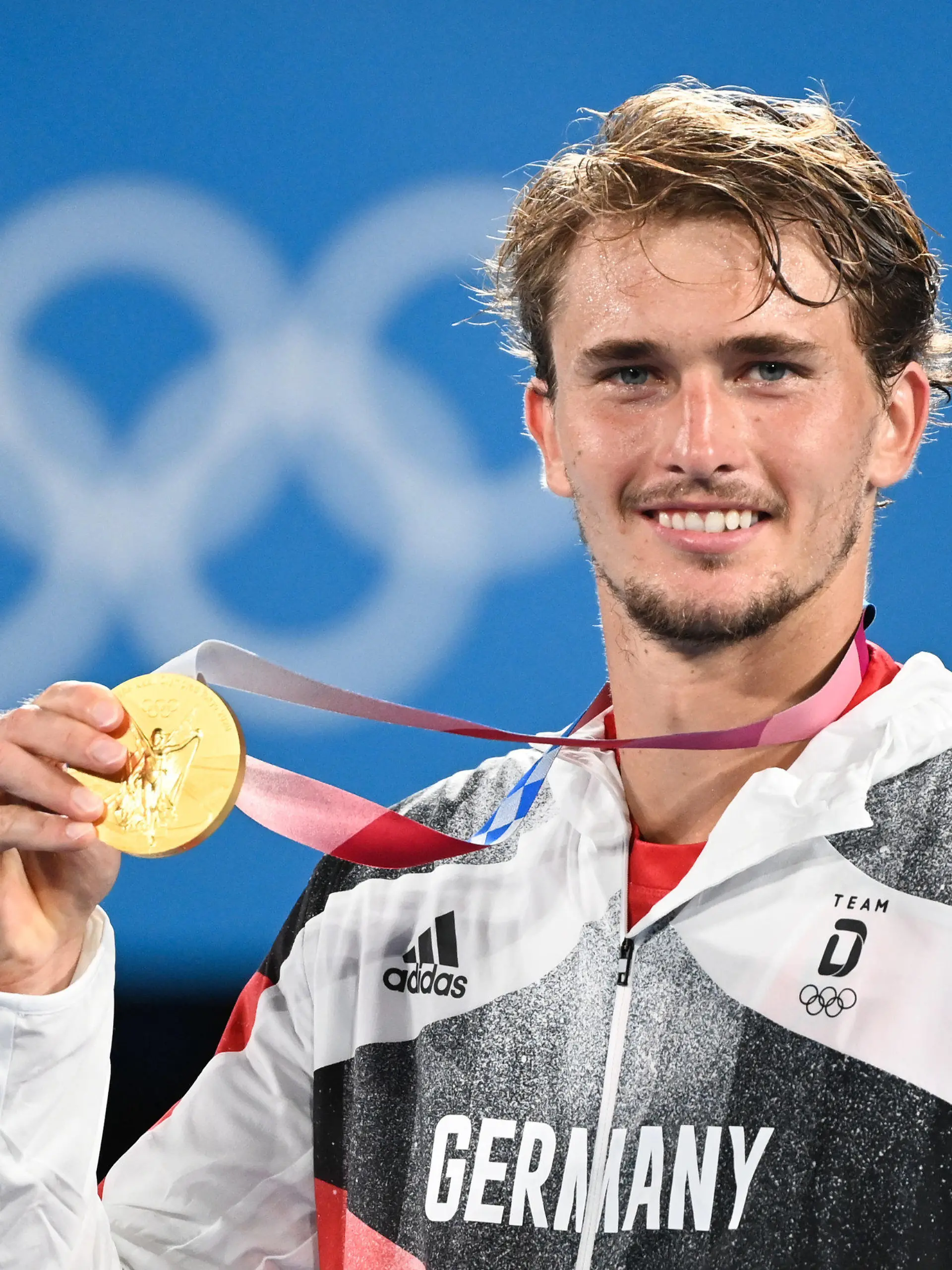 ARCHIV - 01.08.2021, Japan, Tokio: Tennis: Olympia, Einzel, Herren, Finale, Zverev (Deutschland) - Chatschanow (Russisches Olympisches Komitee) im Ariake Tennis Park. Alexander Zverev feiert mit seiner Goldmedaille. Der Tennis-Olympiasieger hat sich für eine Reform der Sportförderung in Deutschland ausgesprochen (zu dpa: «Zverev fordert besseres Unterstützungssystem im deutschen Sport») Foto: Marijan Murat/dpa +++ dpa-Bildfunk +++