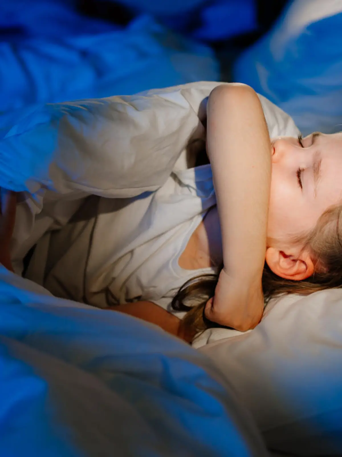 The little girl is sick, lies in bed and coughs. caring for children. restless sleep during illness. cough medicine.
