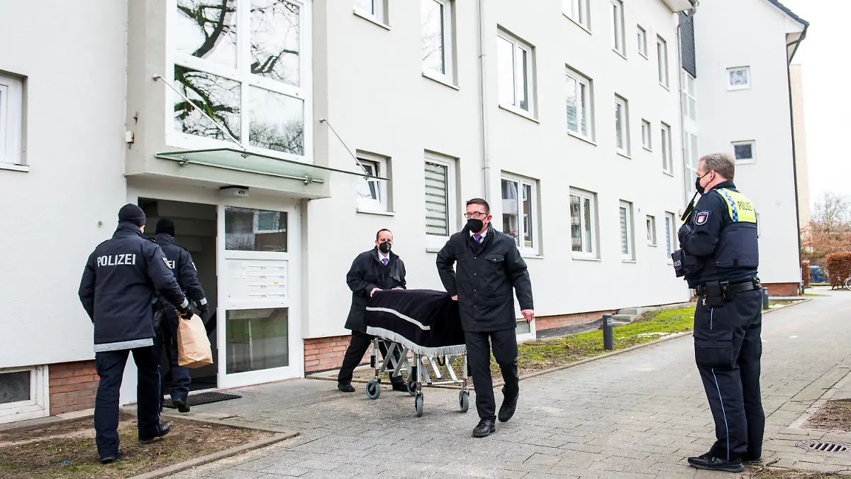 ARCHIV - 08.02.2021, Hamburg: Bestatter transportieren im Februar im Hamburger Stadtteil Bramfeld einen Sarg aus einem Mehrfamilienhaus ab. Ein Mann soll dort am vorherigen Abend seine Mutter umgebracht haben. Etwa einen Tag zuvor soll er auch seine Freundin getötet haben. Nun beginnt das Sicherungsverfahren gegen den 29-Jährigen, dem Totschlag und heimtückischer Mord vorgeworfen wird. (zu dpa: «Mutter und Freundin getötet? - Prozessbeginn gegen 29-Jährigen») Foto: Daniel Bockwoldt/dpa +++ dpa-Bildfunk +++