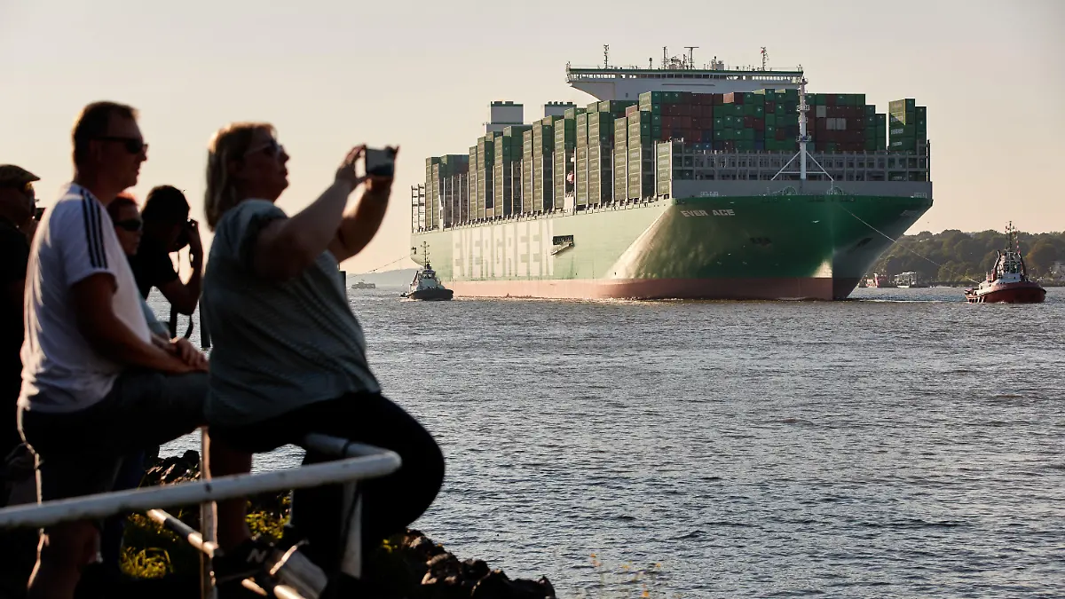 08.09.2021, Hamburg: Schaulustige am Bubendey-Ufer machen Fotos von der Ankunft des Containerschiffs "Ever Ace·. Sie ist eines der größten Containerschiffe der Welt und wurde auf der Elbe von Schleppern in den Hamburger Hafen gelotst, um am Containerterminal Burchardkai festzumachen. Die «Ever Ace» hat Platz für offiziell 23.992 Boxen und 200.000 Tonnen Last. Foto: Georg Wendt/dpa +++ dpa-Bildfunk +++