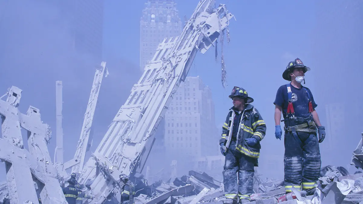 11.09.2001, USA, New York: Feuerwehrleute klettern über die Trümmer des Marriott-Hotels und des in sich zusaamengefallenen zweiten Turms nach dem Terroranschlag auf das World Trade Center. (zu dpa «20 Jahre 9/11: Terroranschläge in den USA») Foto: Randy Taylor/ZUMA Press Wire Service/dpa +++ dpa-Bildfunk +++