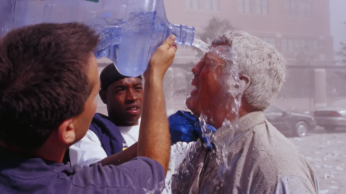 ARCHIV - 11.09.2001, USA, New York: Paasanten spülen nach dem Terroranschlag auf das World Trade Center mit Wasser Staub aus dem Gesicht eines Mannes. (zu dpa «20 Jahre 9/11: Terroranschläge in den USA») Foto: Randy Taylor/ZUMA Press Wire Service/dpa +++ dpa-Bildfunk +++