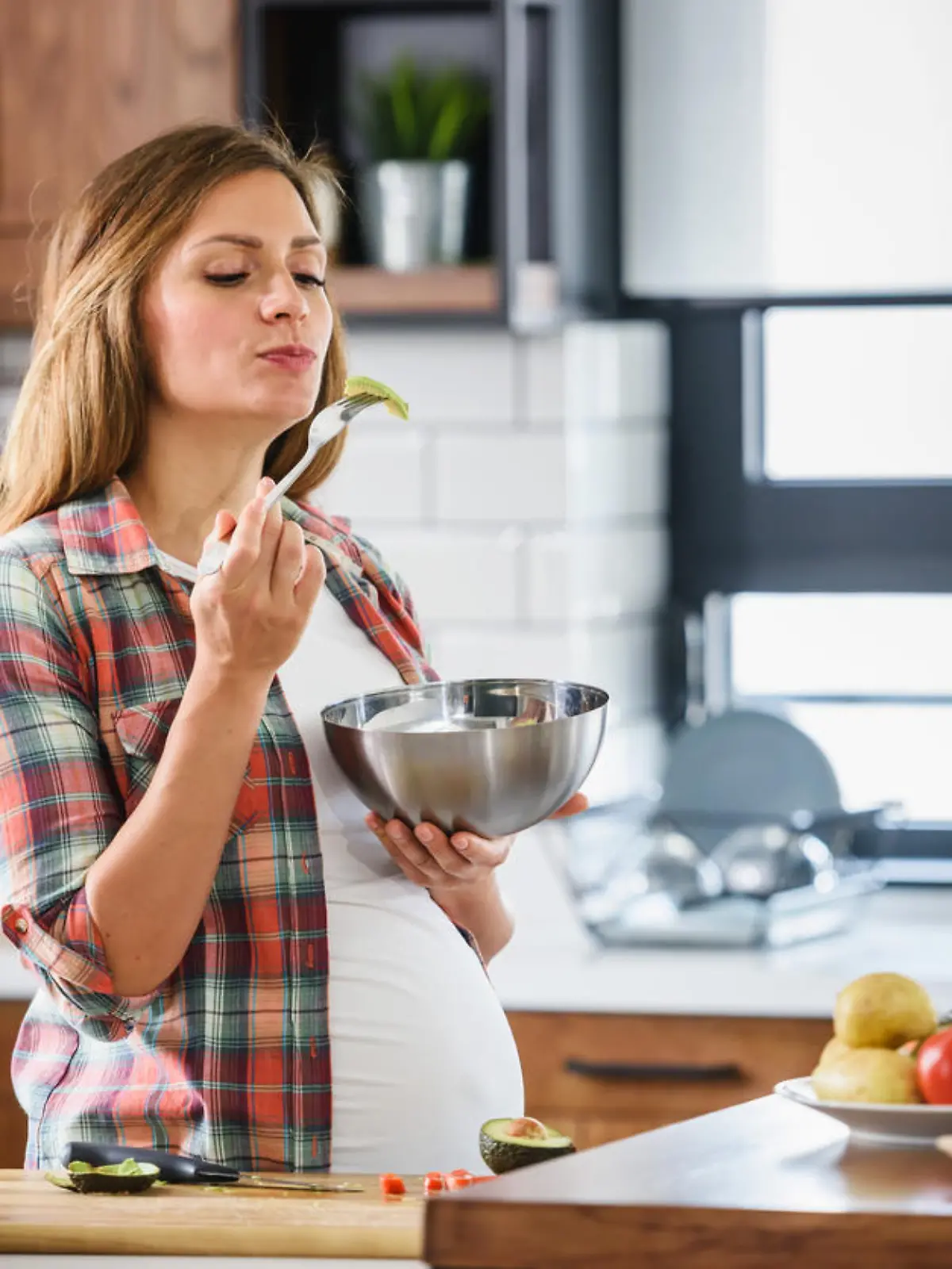 Young beautiful pregnant woman preparing healthy meal with fruites and vegetables