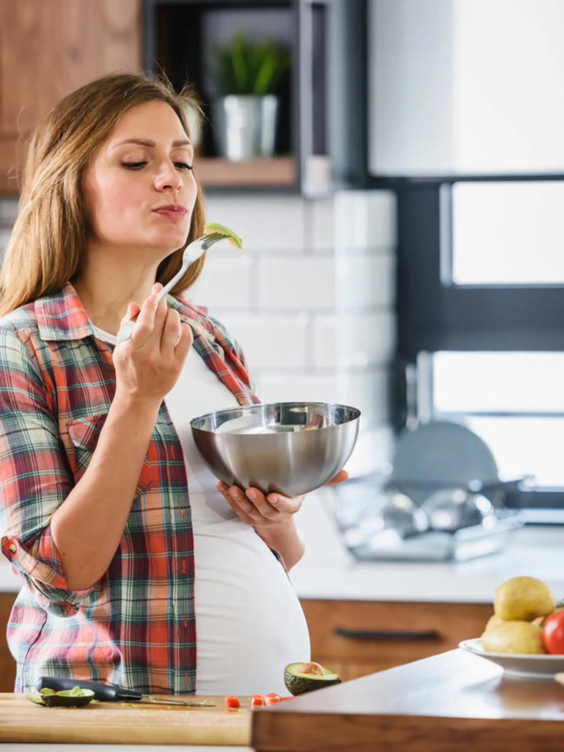 Young beautiful pregnant woman preparing healthy meal with fruites and vegetables