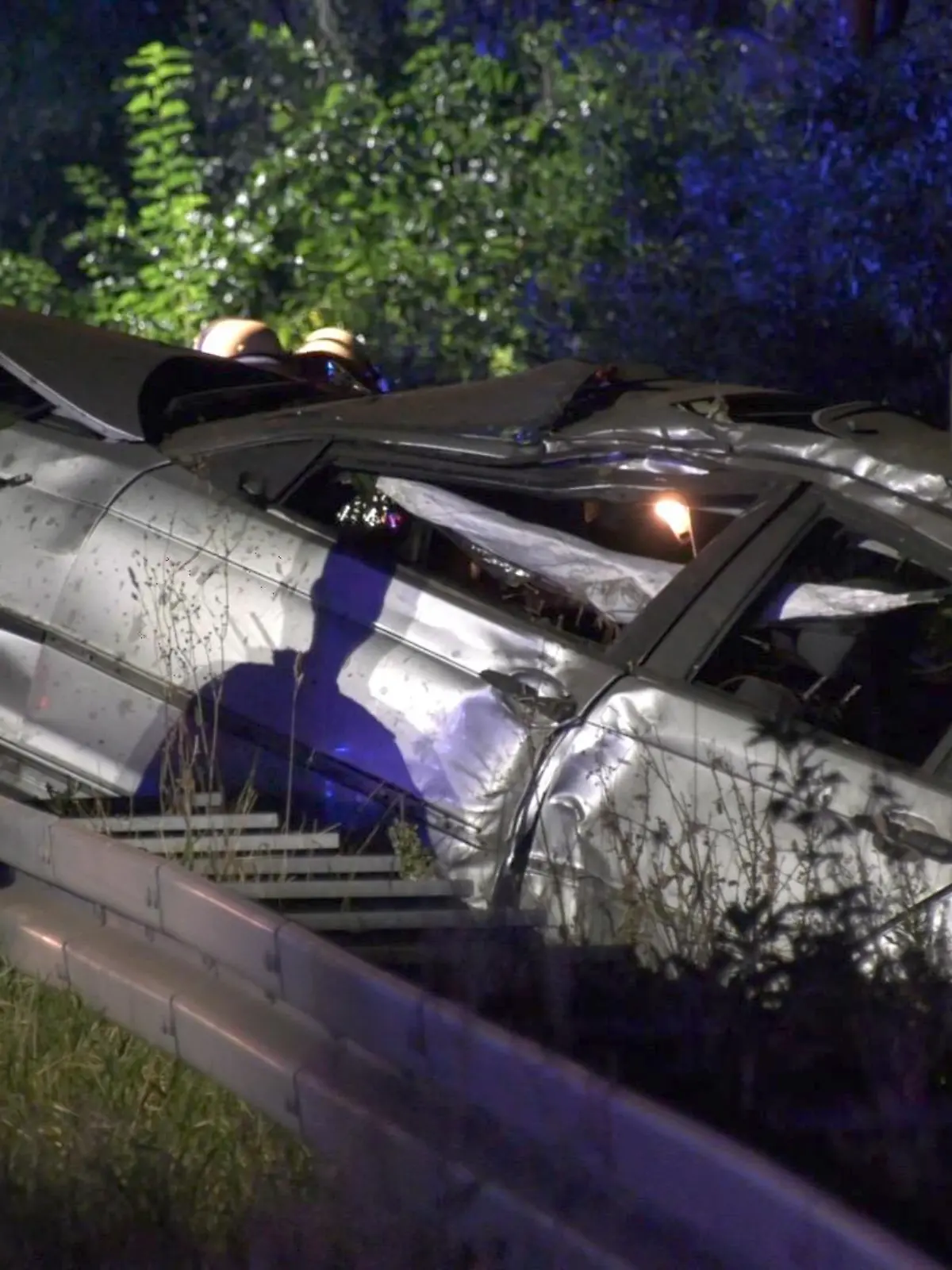 06.09.2021, Hessen, Rüsselsheim: Ein Polizist untersucht das Wrack eines PKW. Am Autobahndreieck Rüsselsheim ist ein Mann von einem Lastwagen überfahren und tödlich verletzt worden. Der Autofahrer wurde zuvor aus seinem Auto geschleudert, wie ein Polizeisprecher am Montag mitteilte. Polizeibeamten fanden das Auto des Mannes in der Nacht auf der Leitplanke der A67 auf Höhe des Autobahnkreuzes. Foto: -/Keutz TV/dpa +++ dpa-Bildfunk +++