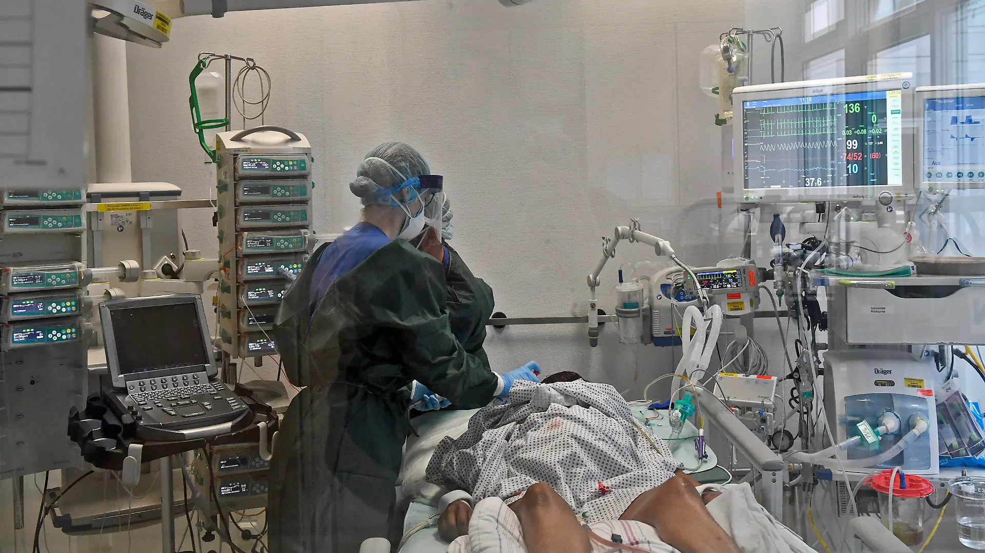 01.07.20, Essen, Nordrhein-Westfalen, Deutschland. Universitaetsklinikum Essen. Intensivstation. Blick in ein Stationszimmer mit Beatmungsgeraet fuer schwersterkrankte Covid-19 Patienten. Aerzte bei der Behandlung einer schwersterkrankten Patientin. Universitaetsklinikum Essen waehrend der Corona Krise *** 01 07 20, Essen, North Rhine-Westphalia, Germany University Hospital Essen Intensive Care Unit View into a ward room with ventilator for critically ill Covid 19 patients Doctors treating a critically ill patient University Hospital Essen during the Corona crisis