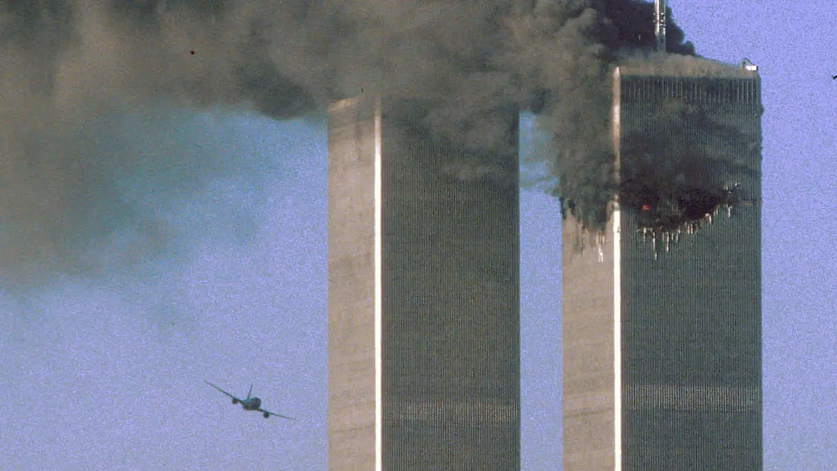 FILE PHOTO: Hijacked United Airlines Flight 175 flies toward the World Trade Center twin towers shortly before slamming into the South tower (L), as the North tower burns, following an earlier attack by a hijacked airliner in New York, U.S., September 11, 2001. REUTERS/Sean Adair/File Photo SEARCH "20TH ANNIVERSARY OF THE SEPTEMBER 11 ATTACKS" FOR THE PHOTOS