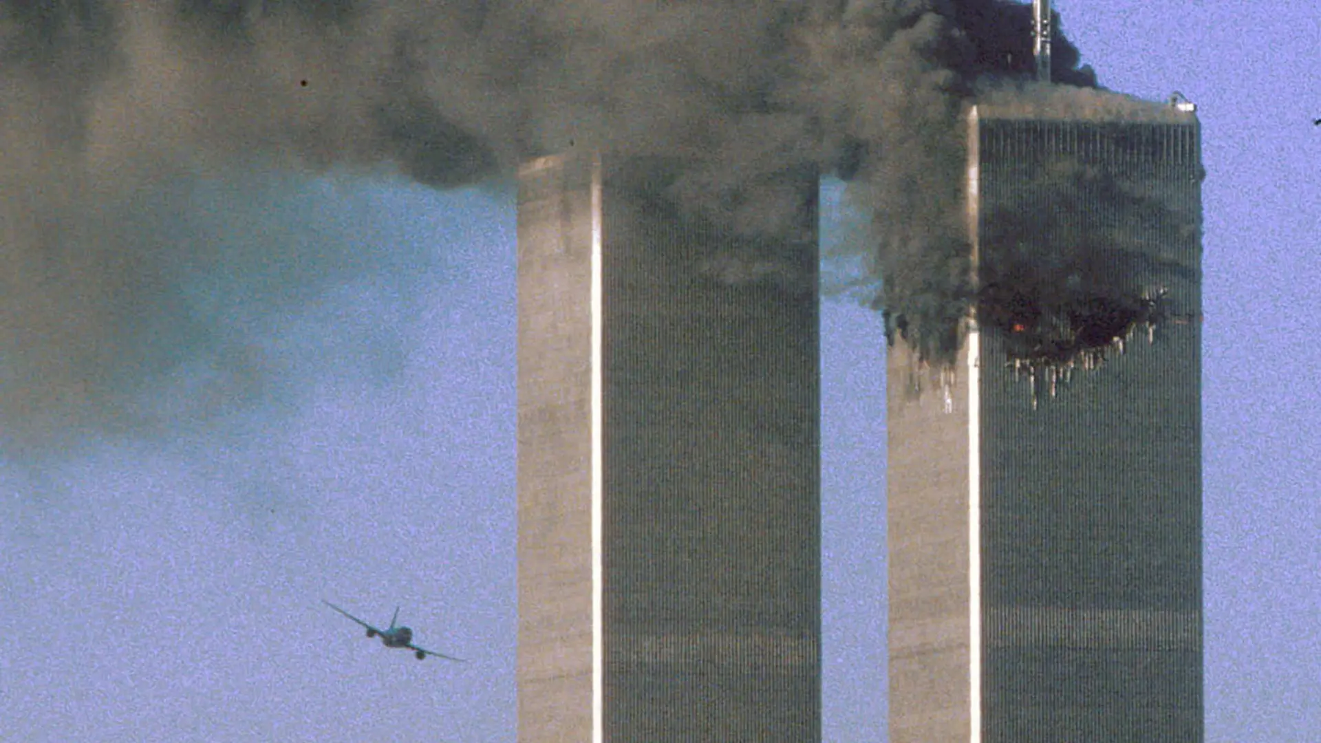 FILE PHOTO: Hijacked United Airlines Flight 175 flies toward the World Trade Center twin towers shortly before slamming into the South tower (L), as the North tower burns, following an earlier attack by a hijacked airliner in New York, U.S., September 11, 2001. REUTERS/Sean Adair/File Photo SEARCH "20TH ANNIVERSARY OF THE SEPTEMBER 11 ATTACKS" FOR THE PHOTOS