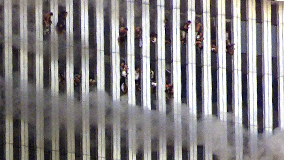 FILE PHOTO: People look out of the burning North tower of the World Trade Center in New York City, New York, U.S. September 11, 2001. REUTERS/Jeff Christensen/File Photo SEARCH "20TH ANNIVERSARY OF THE SEPTEMBER 11 ATTACKS" FOR THE PHOTOS