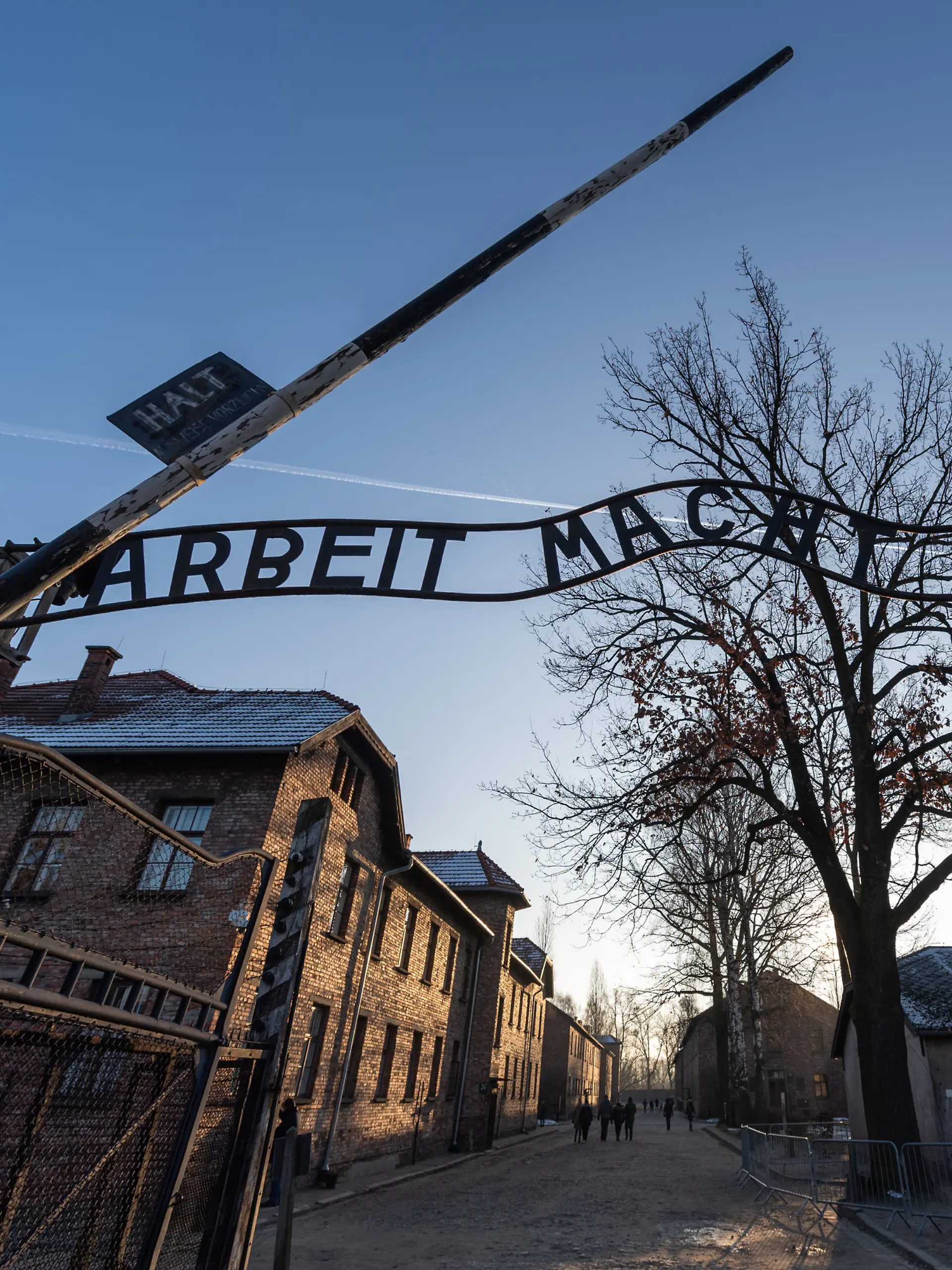 Blick auf das Eingangstor des ehemaligen deutschen Konzentrationslagers Auschwitz mit dem Schriftzug „Arbeit macht frei”