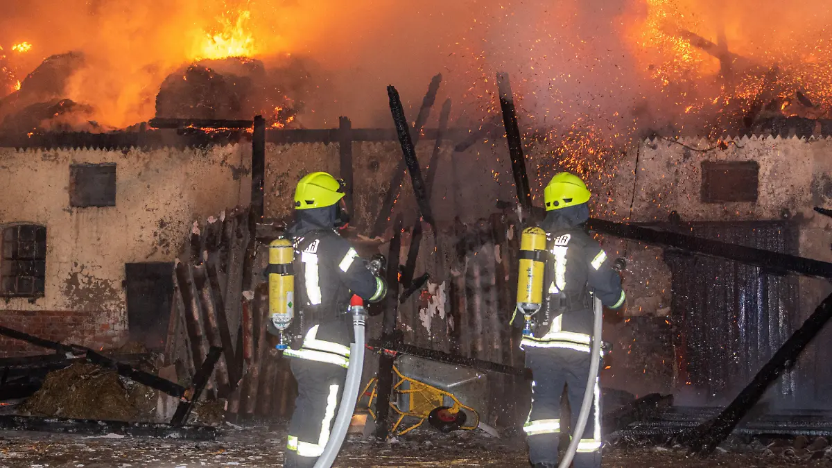 06.09.2021, Niedersachsen, Sottrum: Feuerwehrleute löschen einen Stallbrand. Rund 15 Rinder sind bei einem Feuer in einem Stall in Sottrum (Landkreis Rotenburg) gestorben. Ein Großteil der Rinderherde konnte in der Nacht zum Montag aber aus dem brennenden Stall gerettet werden, wie ein Polizeisprecher am Morgen mitteilte. Das mehr als 100 Jahre alte Gebäude hatte aus zunächst ungeklärten Gründen im Strohlagers des Obergeschosses Feuer gefangen und war komplett niedergebrannt. Foto: JOTO/dpa +++ dpa-Bildfunk +++