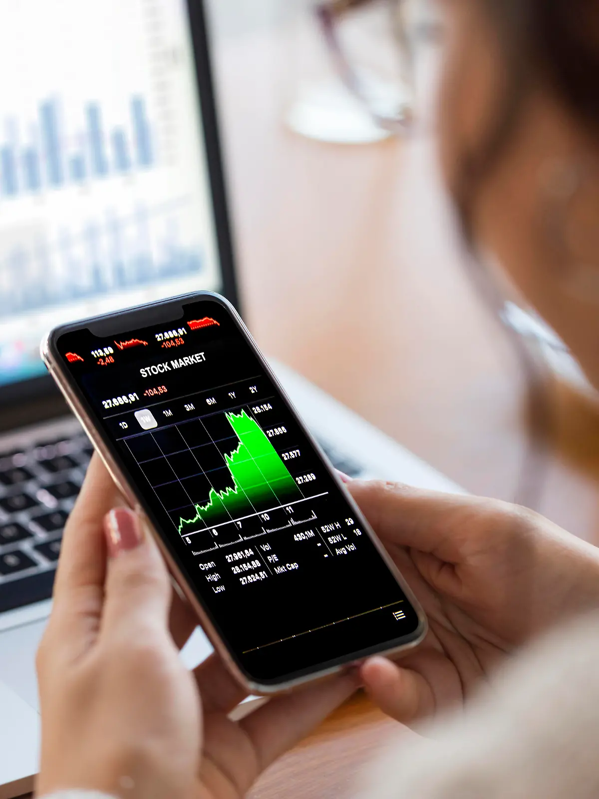 Young finance expert  analyzing financial charts on smart phone