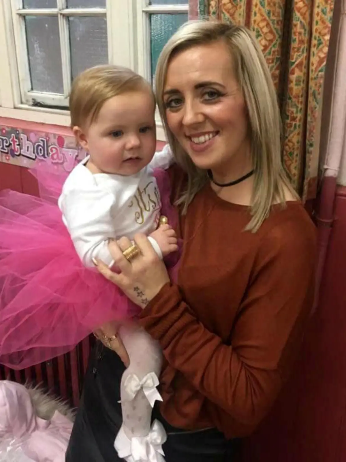Mum Kayley Newbold with her daughter Honey Rose who has just celebrated her first birthday after defying medics who warned her parents she would probably die within hours of being born. See SWNS story SWHOSPICE; Meet a real festive miracle - a baby fought back to survive a risky Boxing Day heart op despite being sent to a hospice to die. Parents Kayley Newbold, 31, and Gary Clark, 34, were told Honey-Rose might only have hours to live after she was diagnosed with a life-threatening condition in the womb. But rather than the blue-skinned baby struggling to breathe that she was warned to expect, Honey-Rose was born pink and healthy-looking, and began to feed after she was born on December 19, 2016. However, the couple were told she would need hospice care - but as they sat beside her cot, they decided to fight for giving their daughter a chance at life and sought a second opinion.