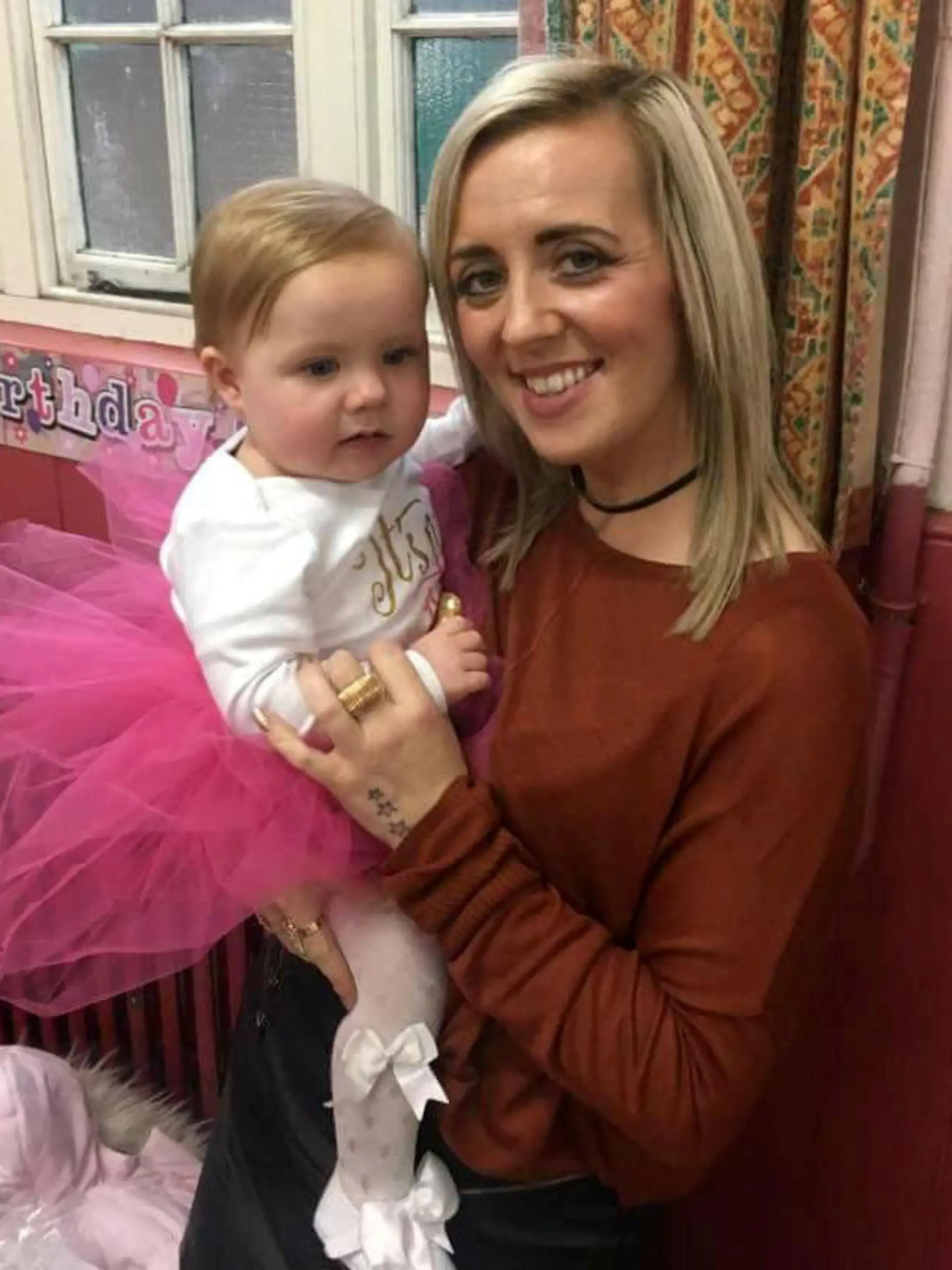Mum Kayley Newbold with her daughter Honey Rose who has just celebrated her first birthday after defying medics who warned her parents she would probably die within hours of being born. See SWNS story SWHOSPICE; Meet a real festive miracle - a baby fought back to survive a risky Boxing Day heart op despite being sent to a hospice to die. Parents Kayley Newbold, 31, and Gary Clark, 34, were told Honey-Rose might only have hours to live after she was diagnosed with a life-threatening condition in the womb. But rather than the blue-skinned baby struggling to breathe that she was warned to expect, Honey-Rose was born pink and healthy-looking, and began to feed after she was born on December 19, 2016. However, the couple were told she would need hospice care - but as they sat beside her cot, they decided to fight for giving their daughter a chance at life and sought a second opinion.