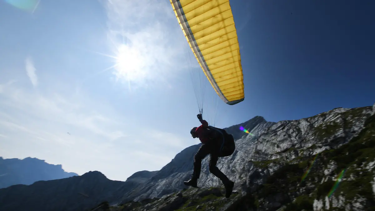 24.08.2019, Bayern, Garmisch-Partenkirchen: Ein Gleitschirmflieger startet bei sonnigem Wetter in der Nähe des Osterfelderkopf im Wetterstein-Gebirge. Foto: Angelika Warmuth/dpa +++ dpa-Bildfunk +++