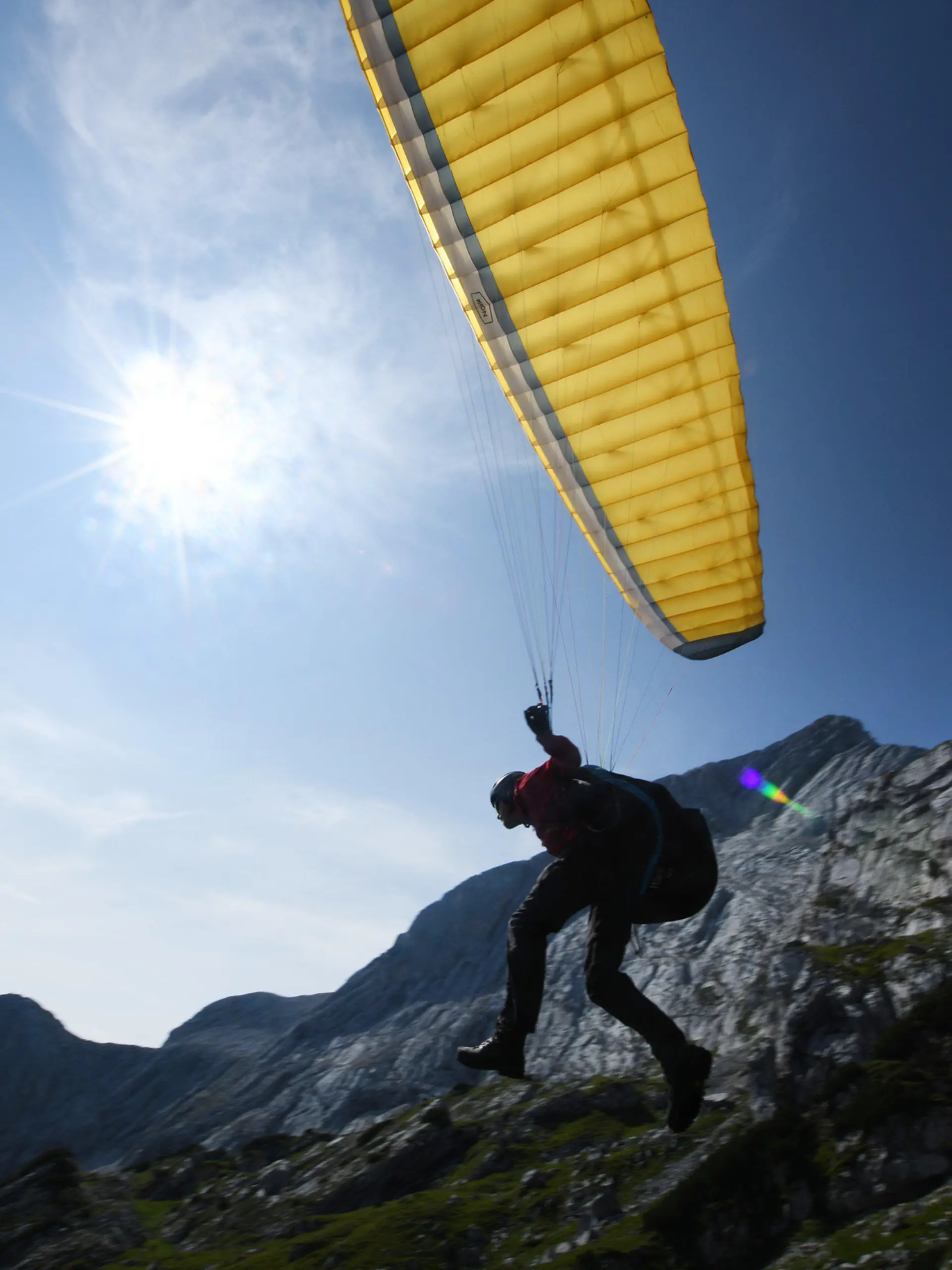 24.08.2019, Bayern, Garmisch-Partenkirchen: Ein Gleitschirmflieger startet bei sonnigem Wetter in der Nähe des Osterfelderkopf im Wetterstein-Gebirge. Foto: Angelika Warmuth/dpa +++ dpa-Bildfunk +++