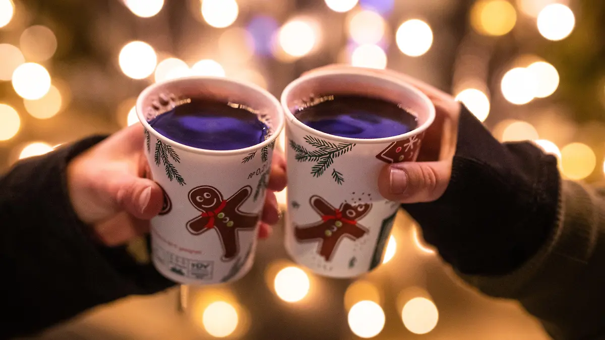 ARCHIV - 07.12.2020, Baden-Württemberg, Stuttgart: Zwei Frauen stoßen mit Glühwein gefüllten Bechern auf dem Weihnachtsmarkt an. (zu dpa «Stuttgarts Weihnachtsmarkt noch unsicher - andere Städte planen fest») Foto: Christoph Schmidt/dpa +++ dpa-Bildfunk +++