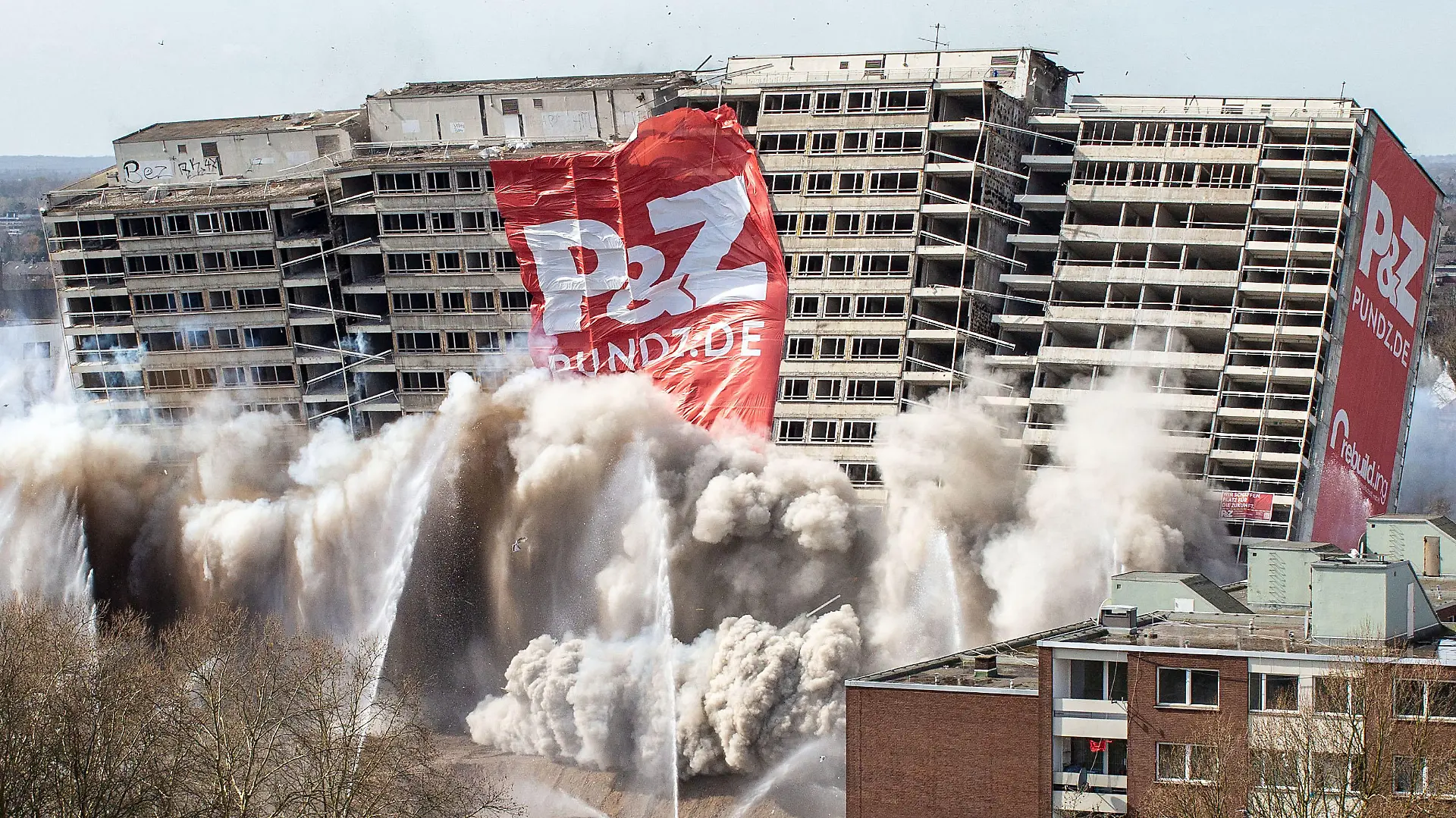 24.03.2019, Nordrhein-Westfalen, Duisburg: Das als «Weißer Riese» bekannte Hochhaus fällt in sich zusammen. Rund 290 Kilogramm Sprengstoff verwandelten es in einen Schutthaufen. Das Gebäude aus dem Jahr 1972 hatte einst 320 Wohnungen. Es galt als eines der größten Wohnhäuser in Nordrhein-Westfalen. Foto: Christoph Reichwein/dpa +++ dpa-Bildfunk +++