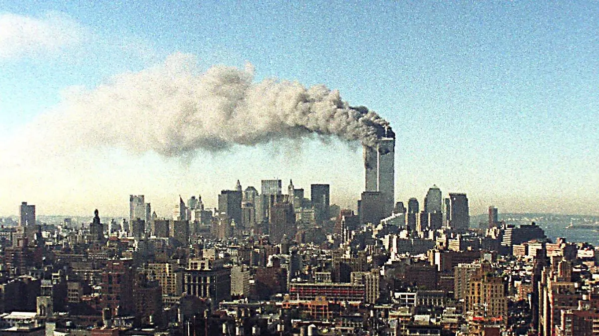 ARCHIV - 11.09.2001, USA, New_York: Blick über das Häusermeer von Manhattan auf die brennenden Zwillingstürme des World Trade Centers. Zwei Flugzeuge sind innerhalb von kürzester Zeit in das World Trade Center in New York gestürzt - der Beginn einer Serie von verheerenden Terroranschlägen in den USA. Die USA gehen davon aus, dass Terroristen dafür verantwortlich sind. Die Zwillingstürme des World Trade Centers sind nach Explosionen im unteren Teil der Gebäude inzwischen eingestürzt. Tausende Menschen sollen verletzt worden sein. (zu dpa «20 Jahre 9/11: Terroranschläge in den USA») Foto: -/Ipol/dpa +++ dpa-Bildfunk +++
