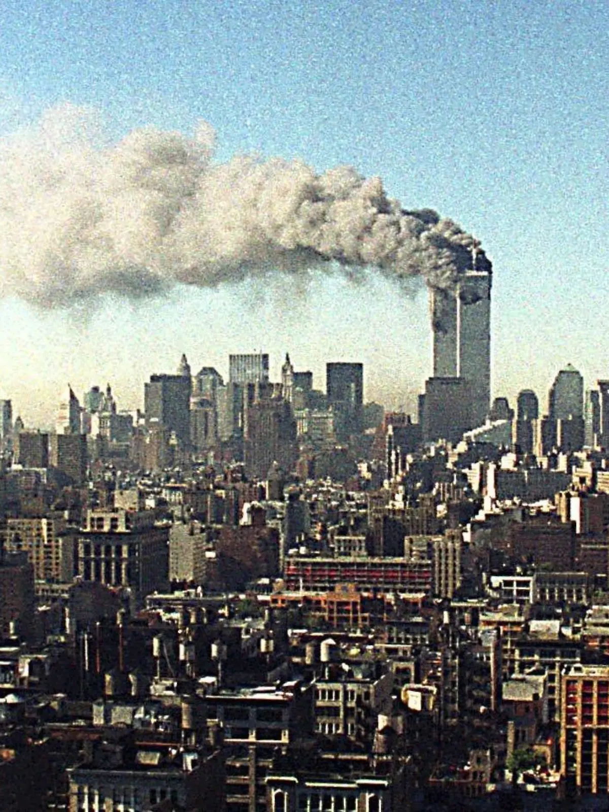 ARCHIV - 11.09.2001, USA, New_York: Blick über das Häusermeer von Manhattan auf die brennenden Zwillingstürme des World Trade Centers. Zwei Flugzeuge sind innerhalb von kürzester Zeit in das World Trade Center in New York gestürzt - der Beginn einer Serie von verheerenden Terroranschlägen in den USA. Die USA gehen davon aus, dass Terroristen dafür verantwortlich sind. Die Zwillingstürme des World Trade Centers sind nach Explosionen im unteren Teil der Gebäude inzwischen eingestürzt. Tausende Menschen sollen verletzt worden sein. (zu dpa «20 Jahre 9/11: Terroranschläge in den USA») Foto: -/Ipol/dpa +++ dpa-Bildfunk +++