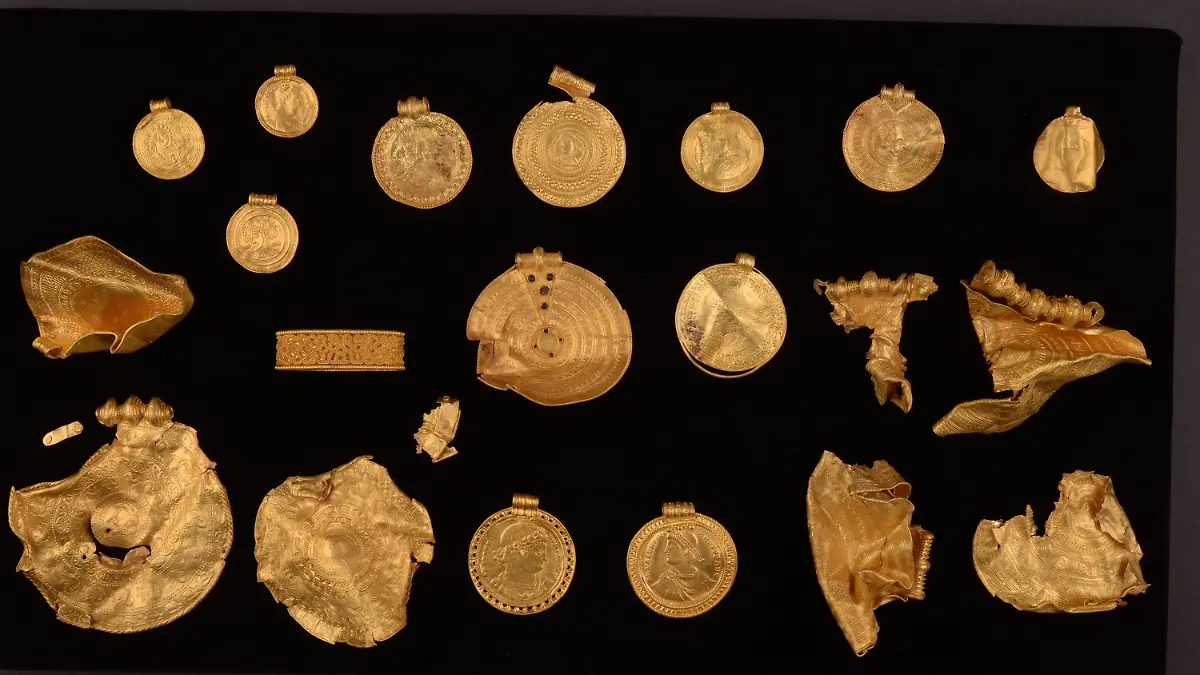 HANDOUT - 27.08.2021, Dänemark, Vejle: Ein 1500 Jahre alter 22-teiliger Goldschatz, bestehend aus fein dekorierten Medaillons, der vermutlich aus dem 5. Jahrhundert stammt. Auch einige römische Münzen, die zu Schmuck verarbeitet wurden, sind darunter. Der Schatz soll vom 3. Februar 2022 an in Vejle ausgestellt werden. (zu dpa «Traumfund»: 1500 Jahre alter Goldschatz in Dänemark entdeckt") Foto: Museumsverbund der Stadt Vejle/dpa - ACHTUNG: Nur zur redaktionellen Verwendung im Zusammenhang mit der aktuellen Berichterstattung und nur mit vollständiger Nennung des vorstehenden Credits +++ dpa-Bildfunk +++