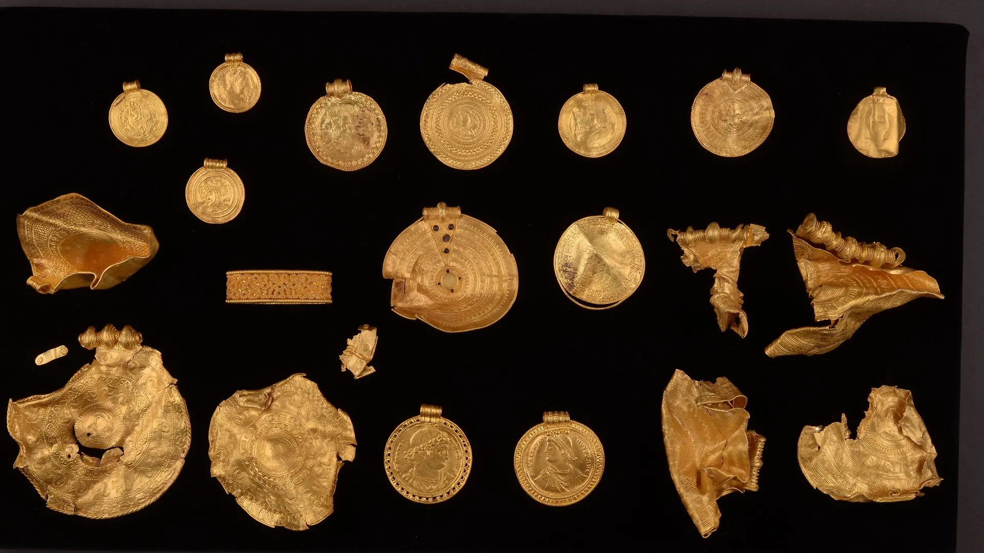 HANDOUT - 27.08.2021, Dänemark, Vejle: Ein 1500 Jahre alter 22-teiliger Goldschatz, bestehend aus fein dekorierten Medaillons, der vermutlich aus dem 5. Jahrhundert stammt. Auch einige römische Münzen, die zu Schmuck verarbeitet wurden, sind darunter. Der Schatz soll vom 3. Februar 2022 an in Vejle ausgestellt werden. (zu dpa «Traumfund»: 1500 Jahre alter Goldschatz in Dänemark entdeckt") Foto: Museumsverbund der Stadt Vejle/dpa - ACHTUNG: Nur zur redaktionellen Verwendung im Zusammenhang mit der aktuellen Berichterstattung und nur mit vollständiger Nennung des vorstehenden Credits +++ dpa-Bildfunk +++