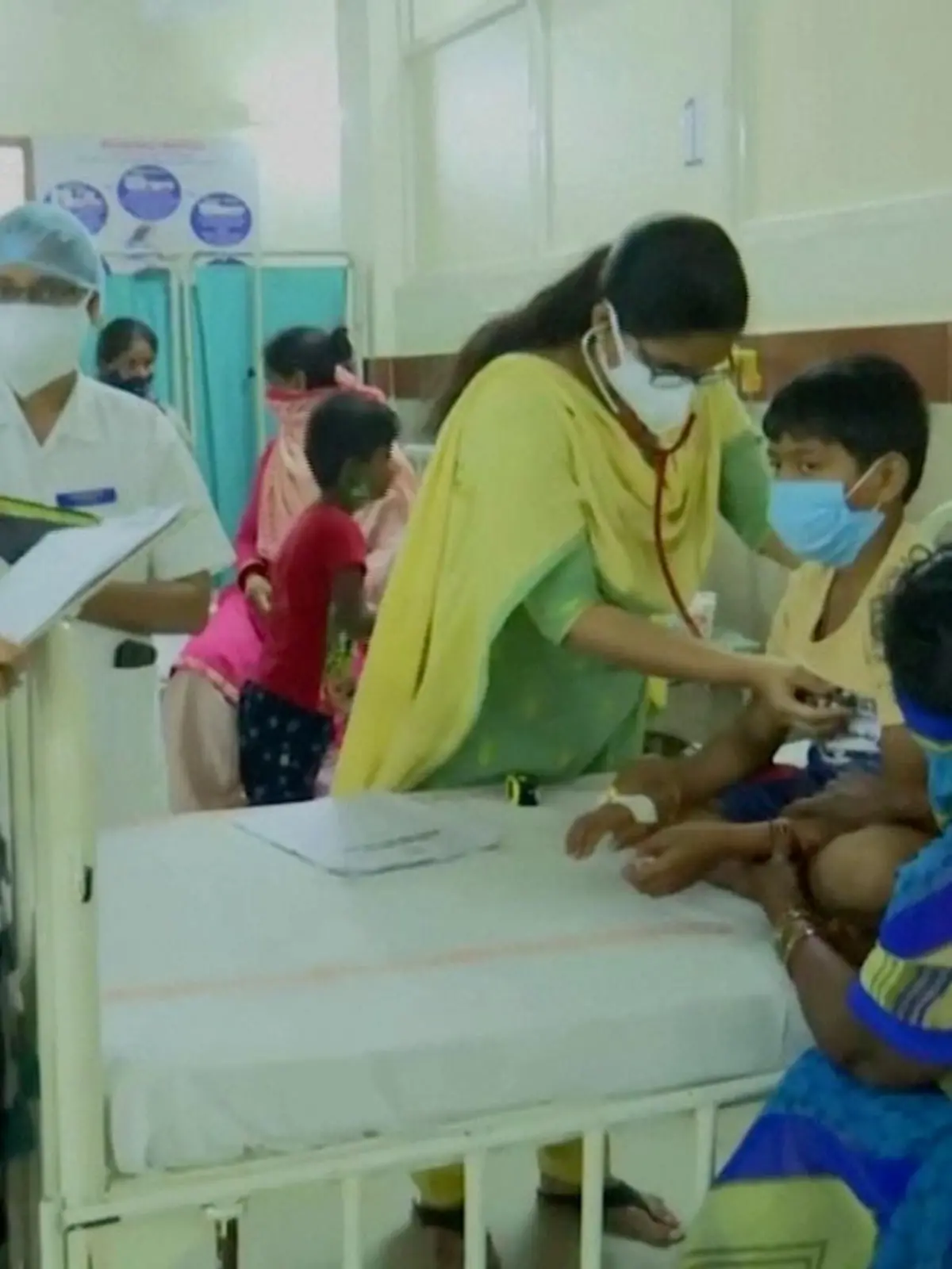 A doctor examines a young patient lying in a hospital bed at an Eluru hospital, after hundreds of people were hospitalised due to an unknown illness in the southern state of Andhra Pradesh, in this still frame taken from video dated December 9, 2020. ANI/Reuters TV/via REUTERS  THIS IMAGE HAS BEEN SUPPLIED BY A THIRD PARTY.NO RESALES. NO ARCHIVES. INDIA OUT. FOR REUTERS CUSTOMERS ONLY.