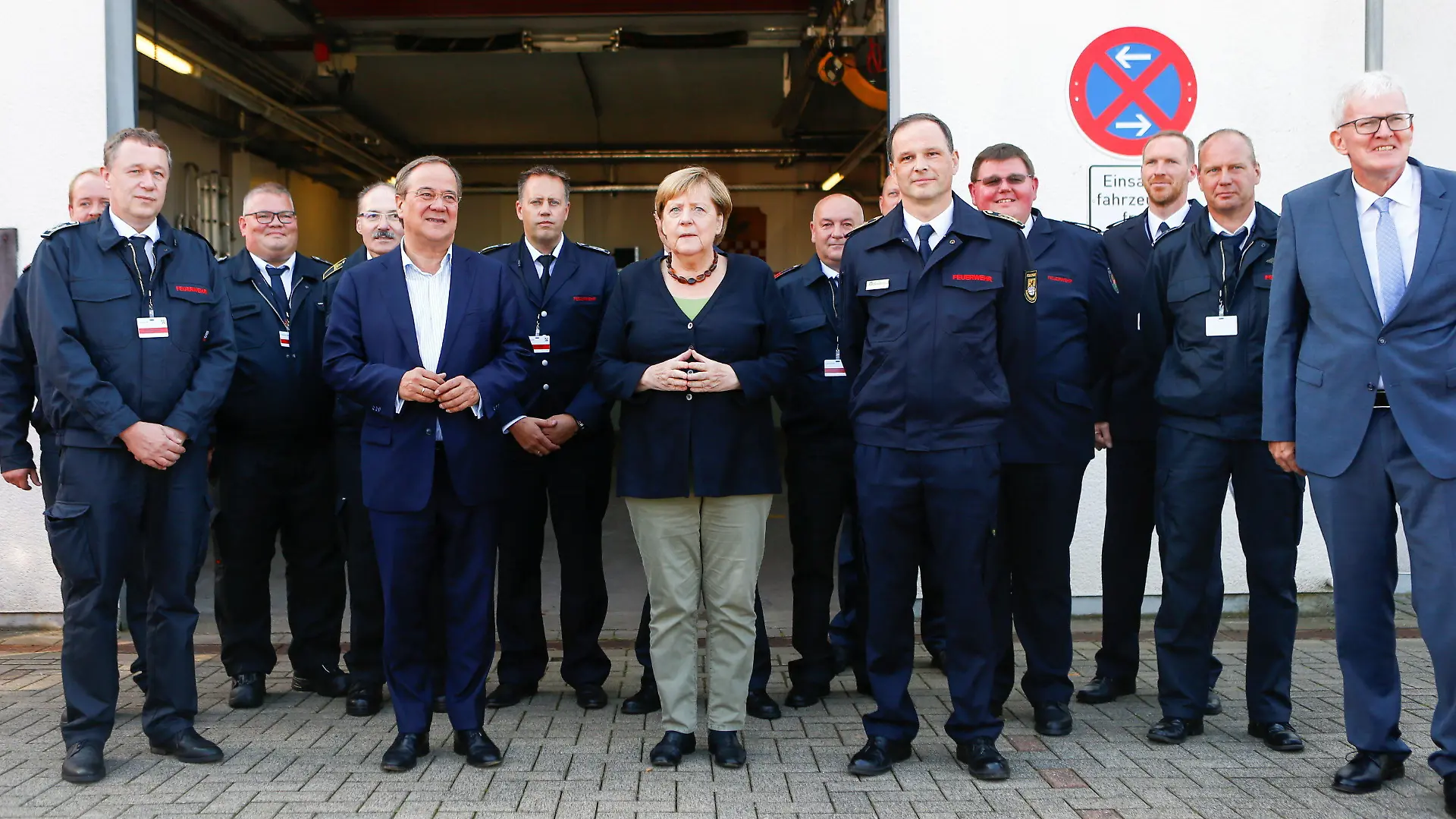 05.09.2021, Nordrhein-Westfalen, Schalksmühle: Bundeskanzlerin Angela Merkel (CDU) und Armin Laschet (5.v.l), Kanzlerkandidat der Union und Vorsitzender der CDU, stehen mit Feuerwehrleuten für ein Foto zusammen. Merkel hat am Sonntag in Schalksmühle im Sauerland Kollegen zweier im Hochwasser-Einsatz gestorbener Feuerwehrleute getroffen. Foto: Thilo Schmuelgen/Reuters Pool/dpa +++ dpa-Bildfunk +++