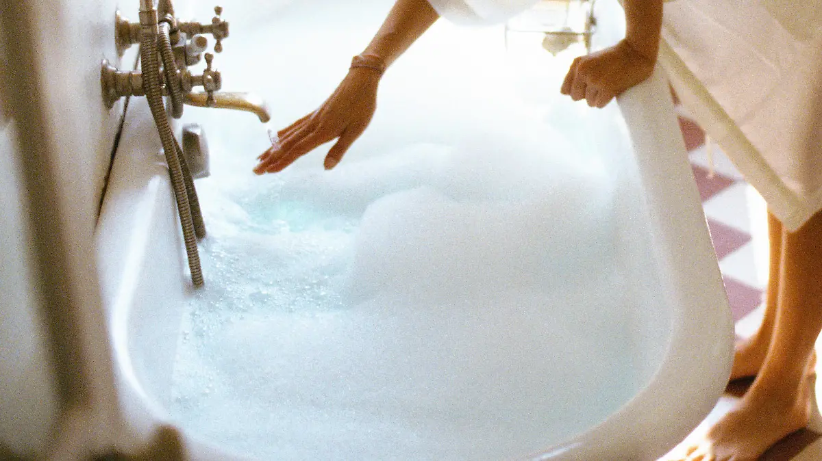 Frau läßt die Badewanne volllaufen