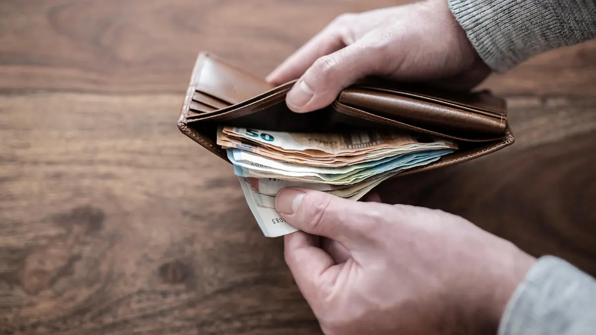 close-up of person counting stack of paper cash in wallet