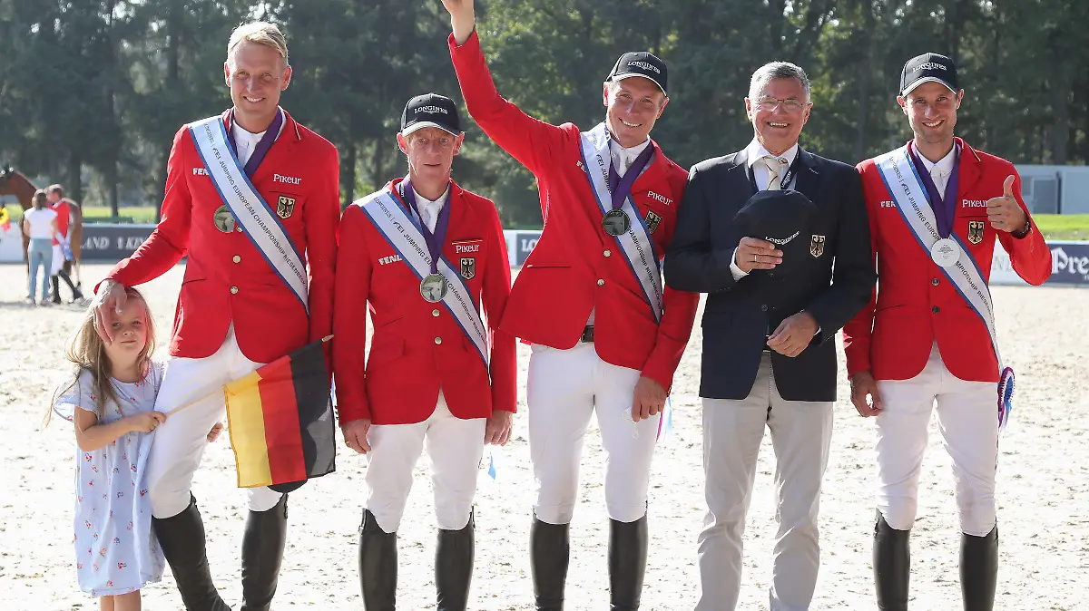 03.09.2021, Nordrhein-Westfalen, Riesenbeck: Pferdesport: Europameisterschaft, Springen. Die deutschen Springreiter Andre Thieme (l-r, mit Tochter Johanna), Marcus Ehning, David Will, Bundestrainer Otto Becker und Christian Kukuk freuen sich über den Gewinn der Silbermedaille in der Mannschaftswertung. Foto: Friso Gentsch/dpa +++ dpa-Bildfunk +++