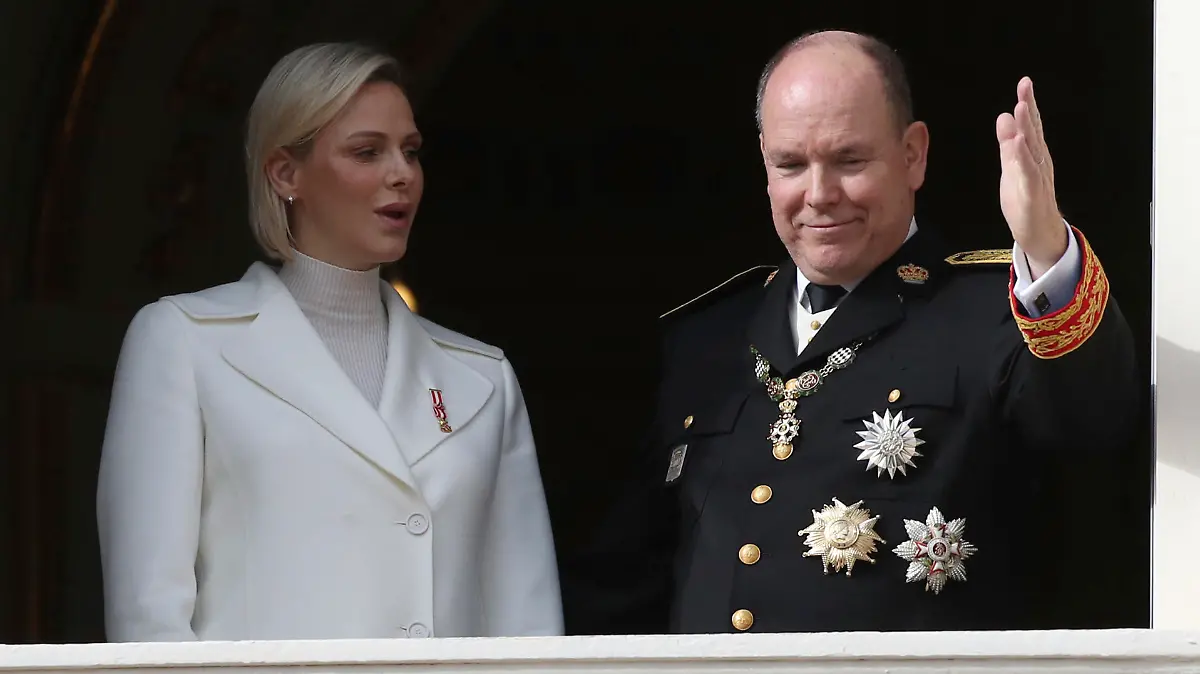 FILE - In this Nov.19, 2019 file photo Prince Albert II of Monaco with his wife Princess Charlene wave from the balcony during the ceremony marking the National Day in Monaco. The palace of Monaco says Prince Albert II has tested positive for the new coronavirus but his health is not worrying. For most people, the new coronavirus causes only mild or moderate symptoms. For some it can cause more severe illness. (AP Photo/Daniel Cole, File)