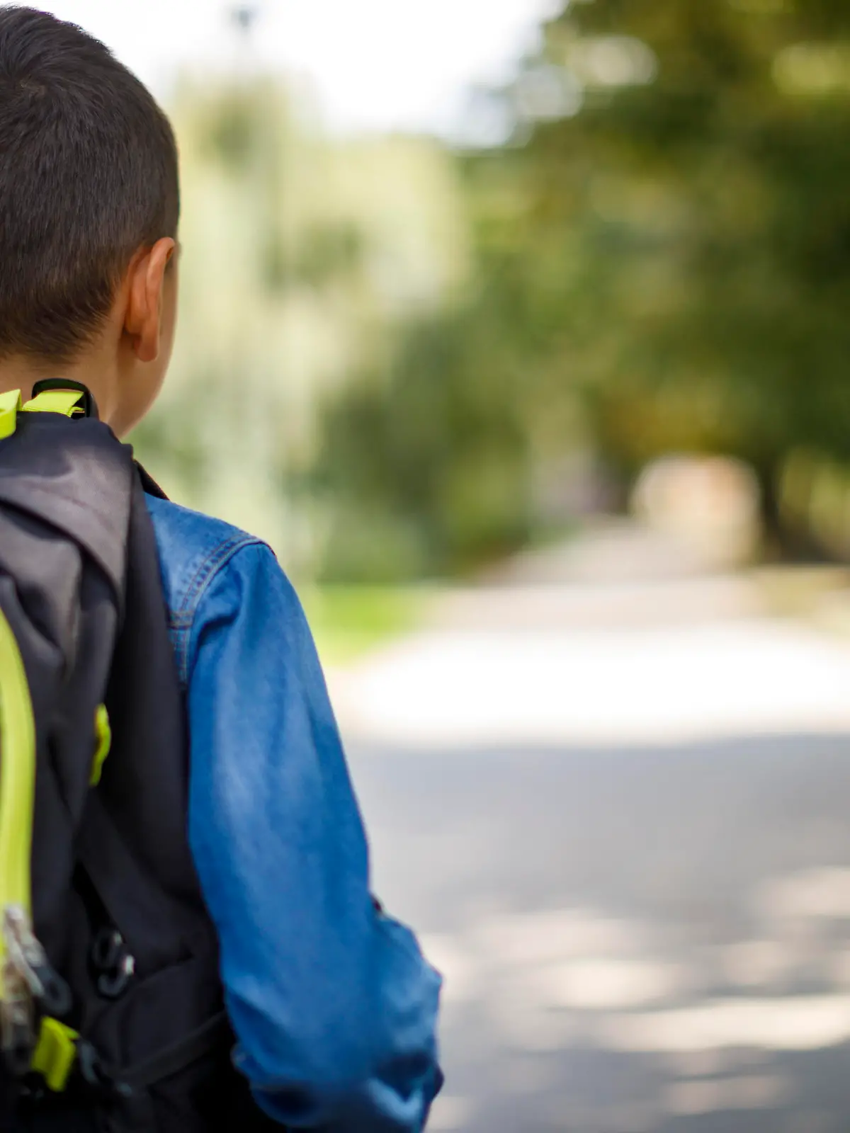 Teenage boy with school bag going home from school