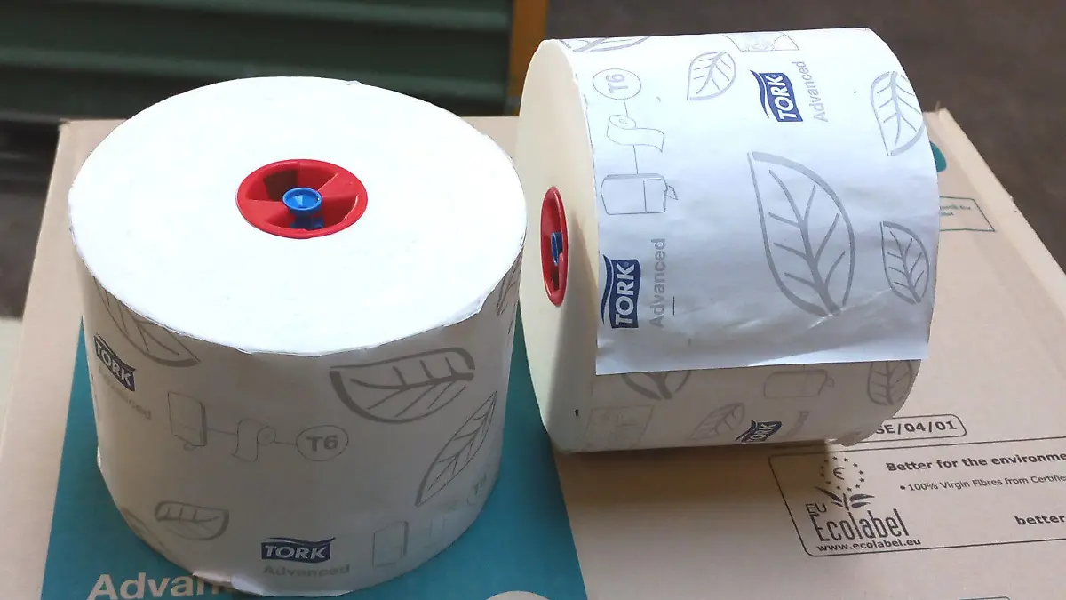 Eine Klopapierrolle liegt auf dem dazugehörigen Karton.