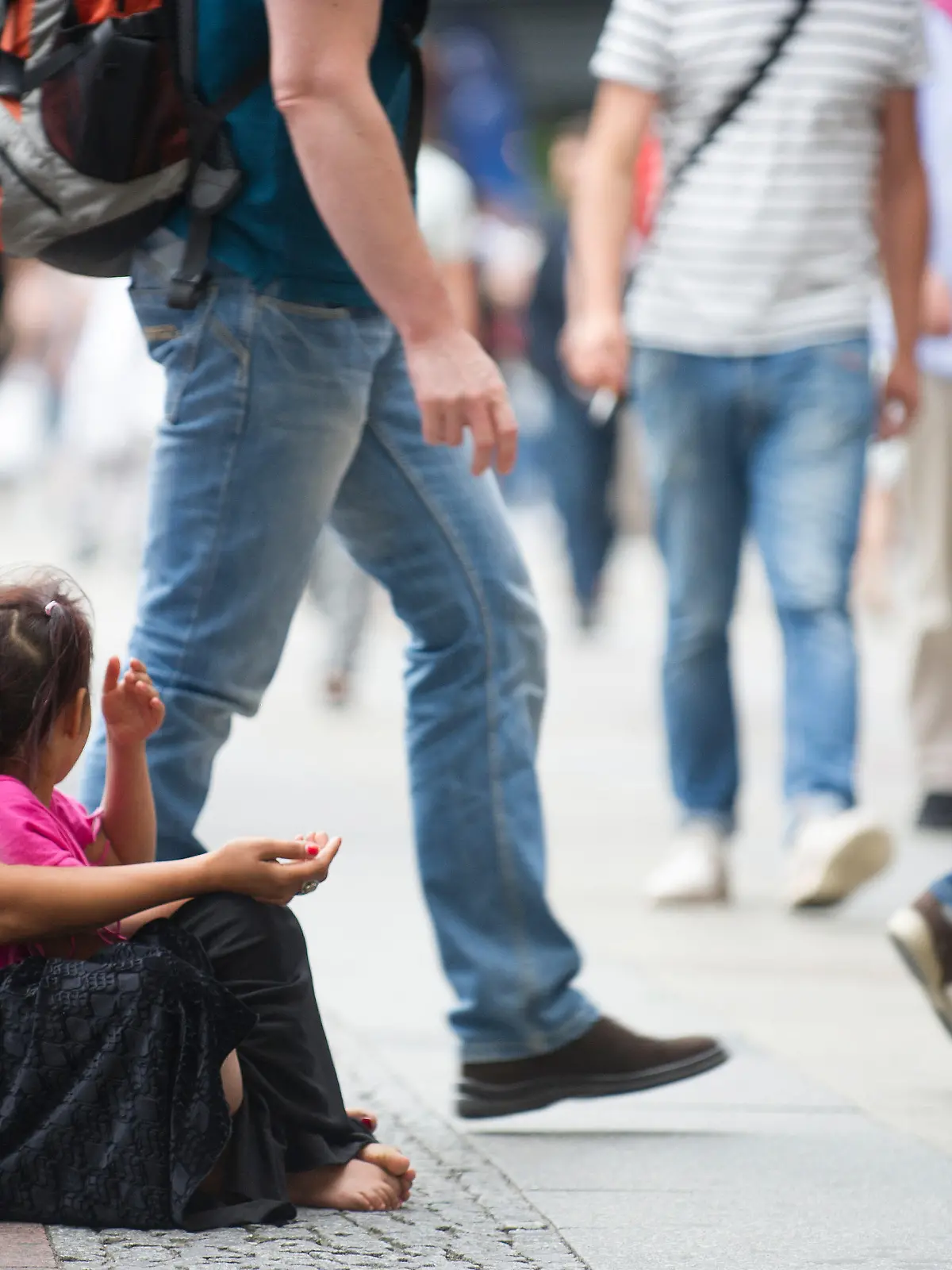 Eine Frau und ein Kind sitzen am 08.07.2015 in Berlin auf einem Bürgersteig und betteln um Geld. Foto: Paul Zinken/dpa (zu dpa «Die bettelnden Kinder von Berlin» vom 23.07.2015) +++(c) dpa - Bildfunk+++