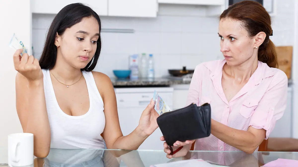 Teenage girl asks her mother some cash in kitchen
