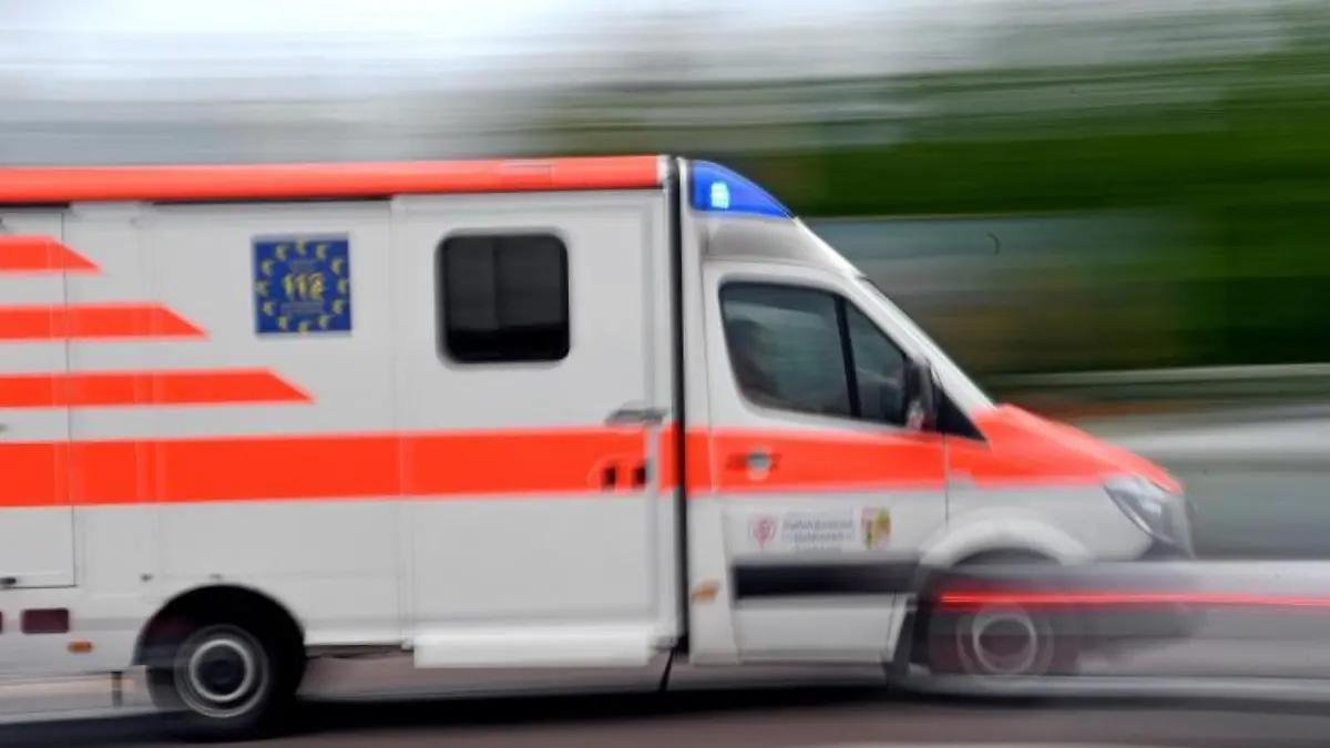 Ein Krankenwagen fährt mit Blaulicht durch die Innenstadt