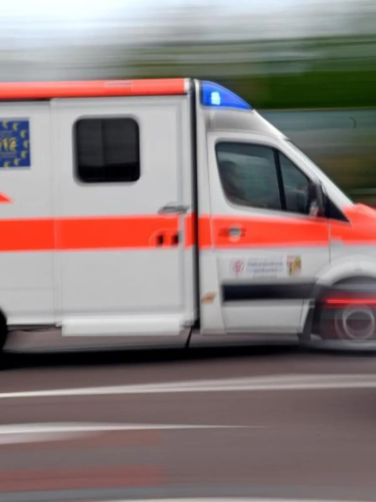 Ein Krankenwagen fährt mit Blaulicht durch die Innenstadt
